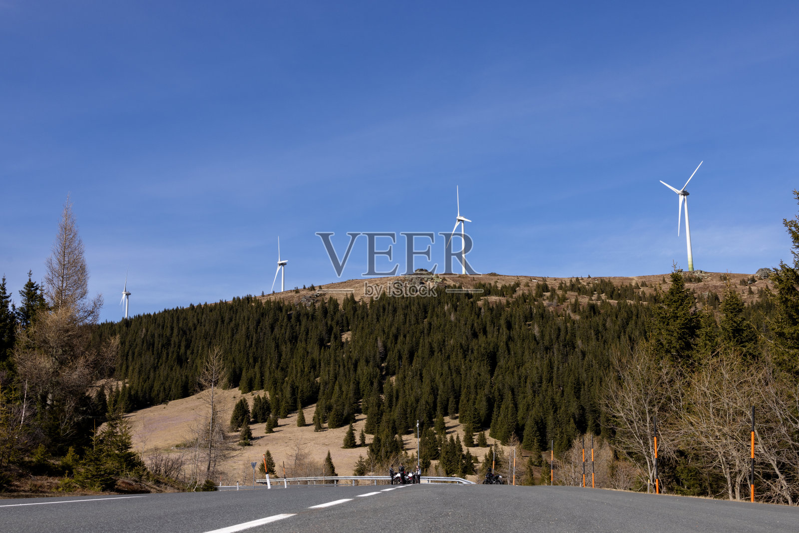 青山上一排风车，映衬着蓝天。前景中的道路照片摄影图片