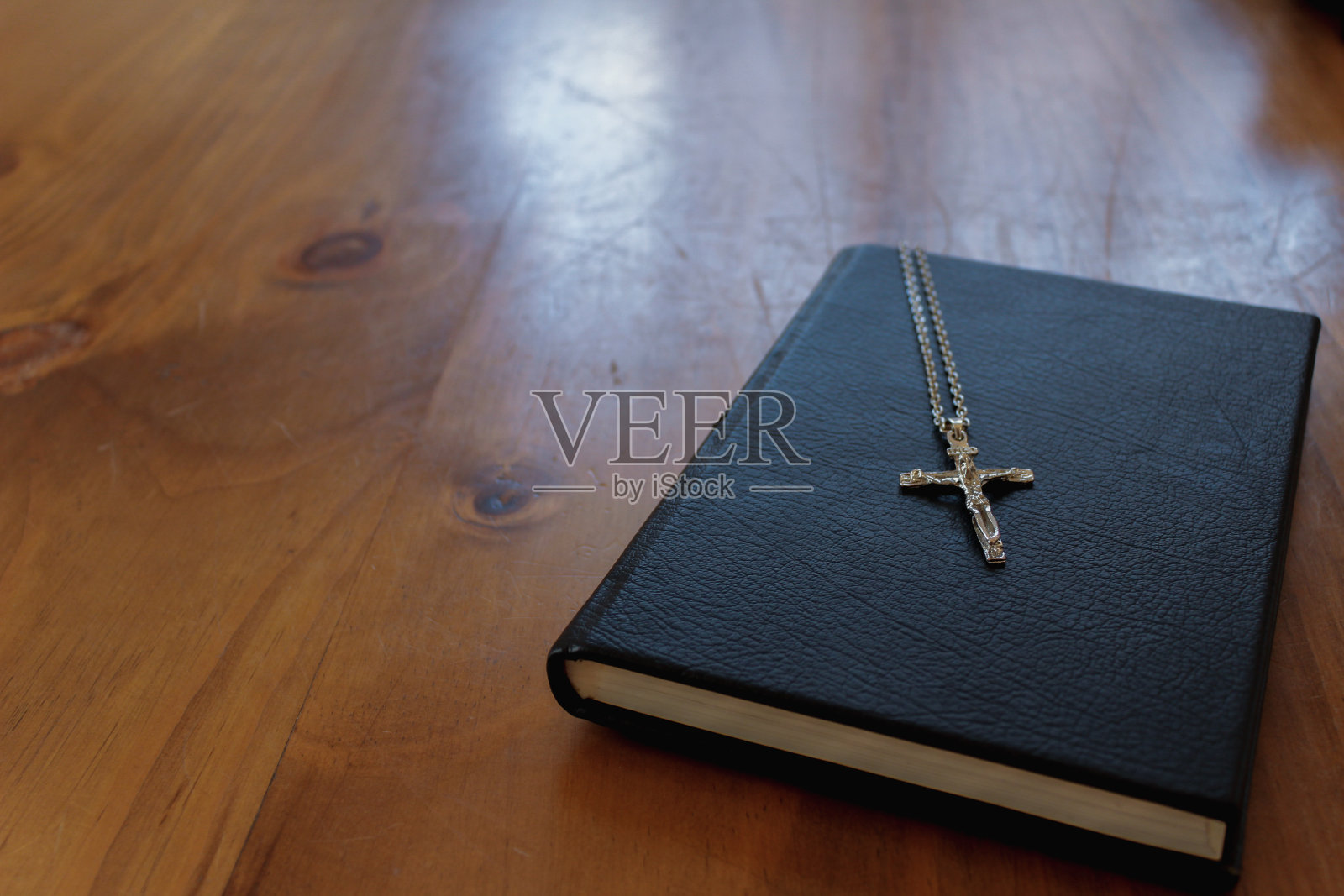 十字架是在向上帝祈祷后放在圣经上的，这是基督教的宗教仪式，是对上帝教义的信仰。用圣经和十字架的教导向神祷告的概念。照片摄影图片