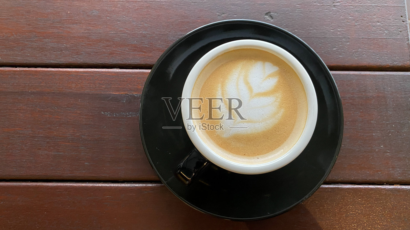 一杯热卡布奇诺在木桌上照片摄影图片