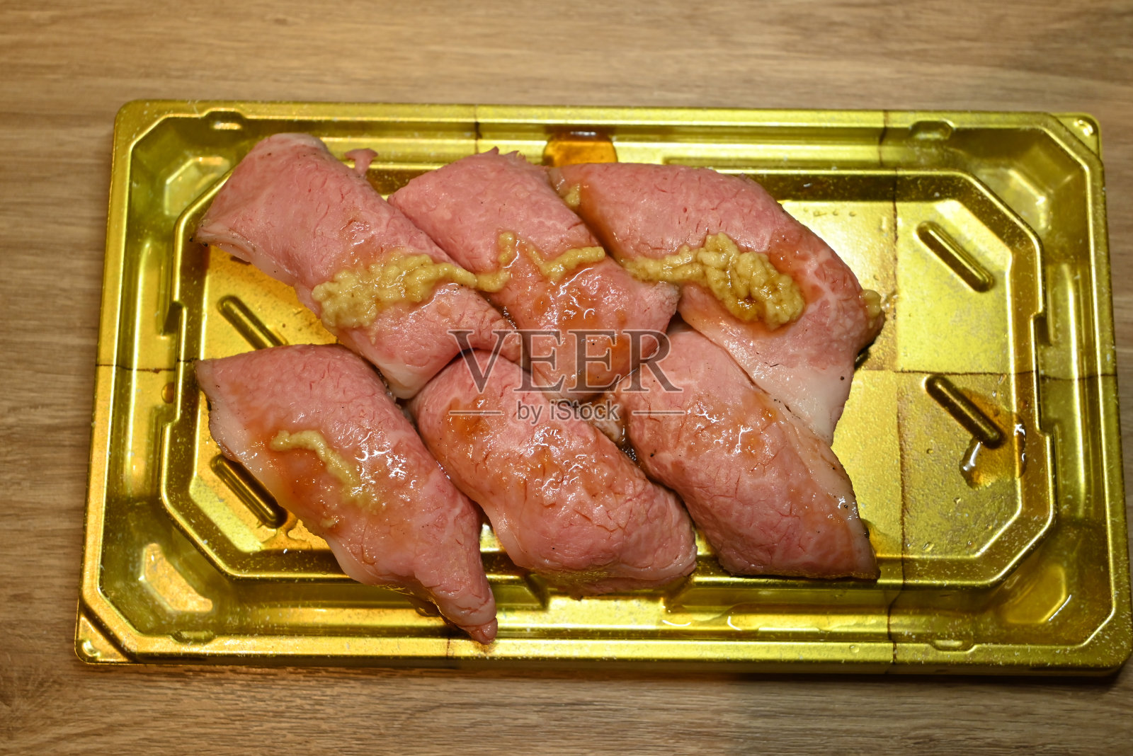 鲜牛肉寿司，黄盘子里放着黄芥末照片摄影图片