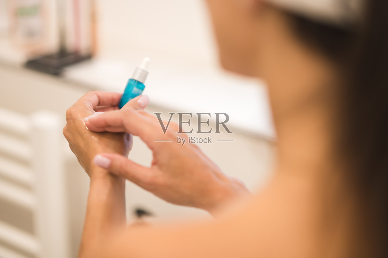 在皮肤上涂抹抗衰老精华液的妇女照片摄影图片