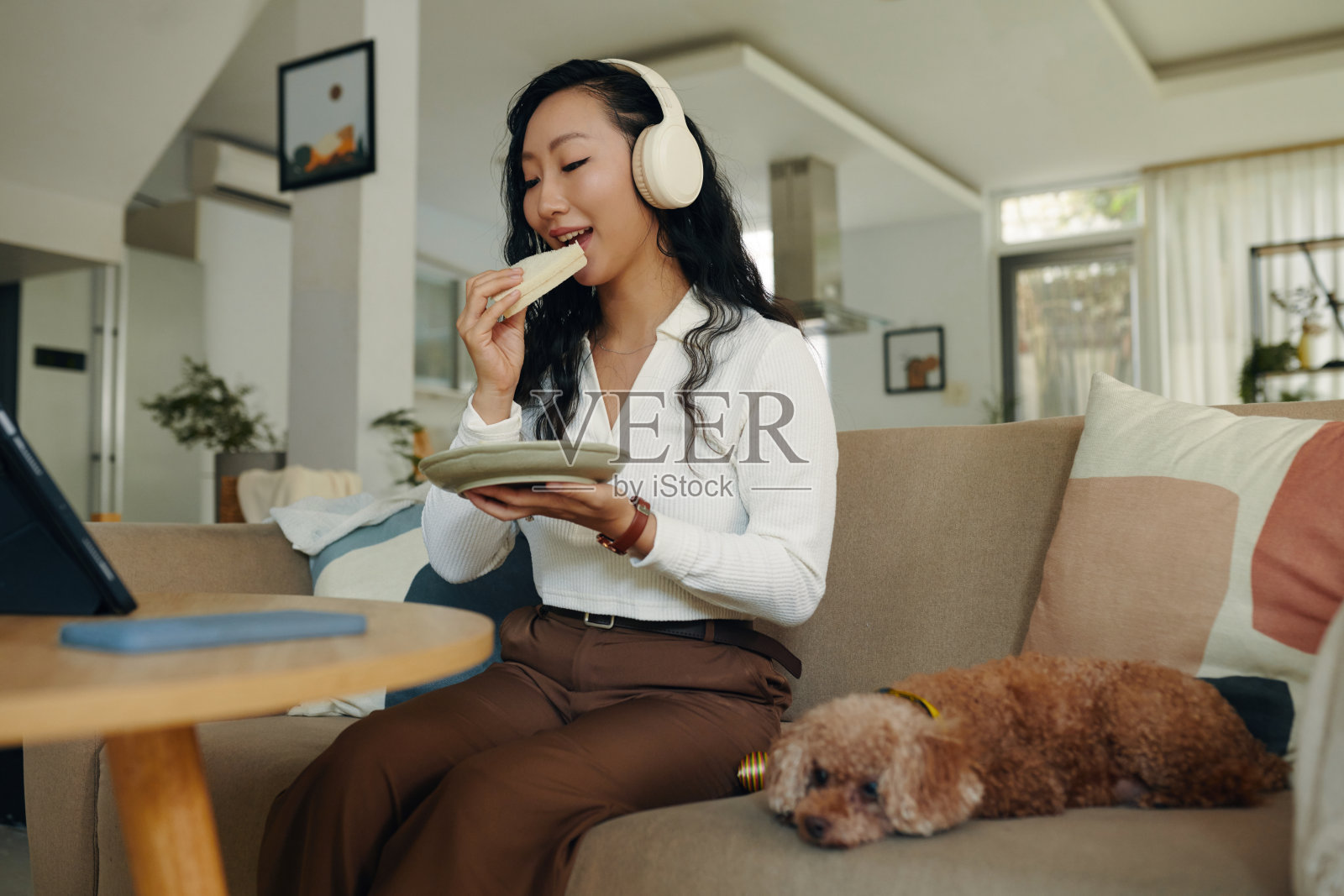 女人一边吃三明治一边看网络研讨会照片摄影图片