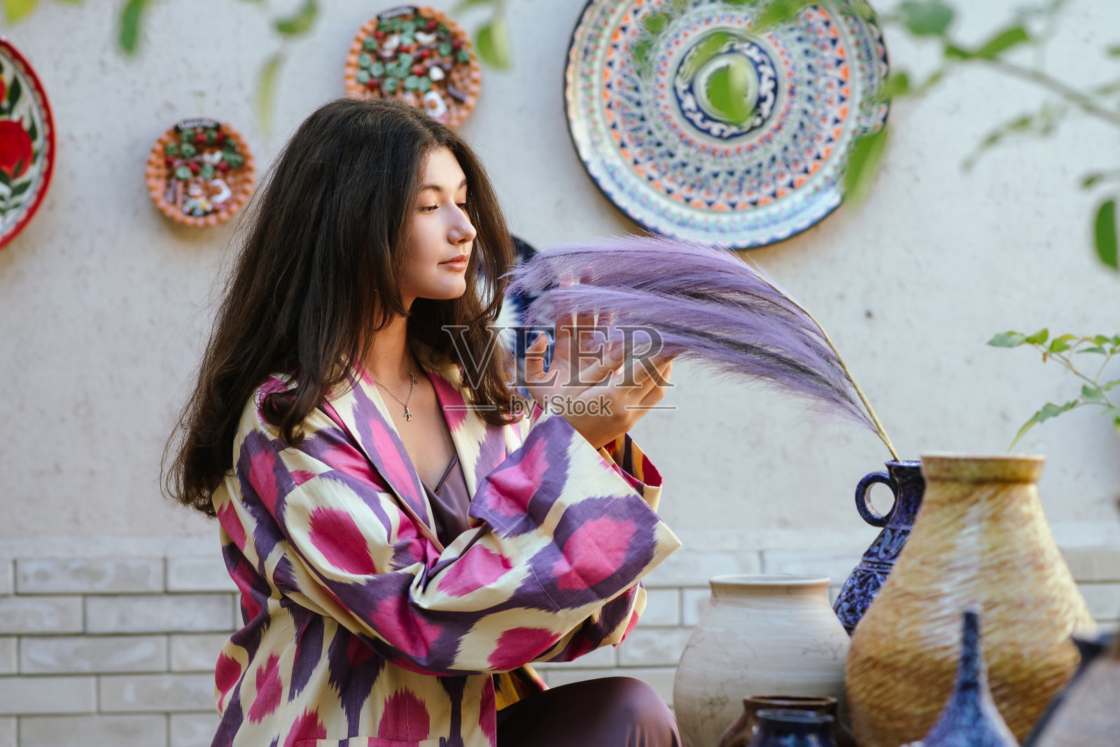 美丽的女人，模特，女孩在乌兹别克斯坦民族民间时尚服装观看陶瓷。塔什干,乌兹别克斯坦照片摄影图片