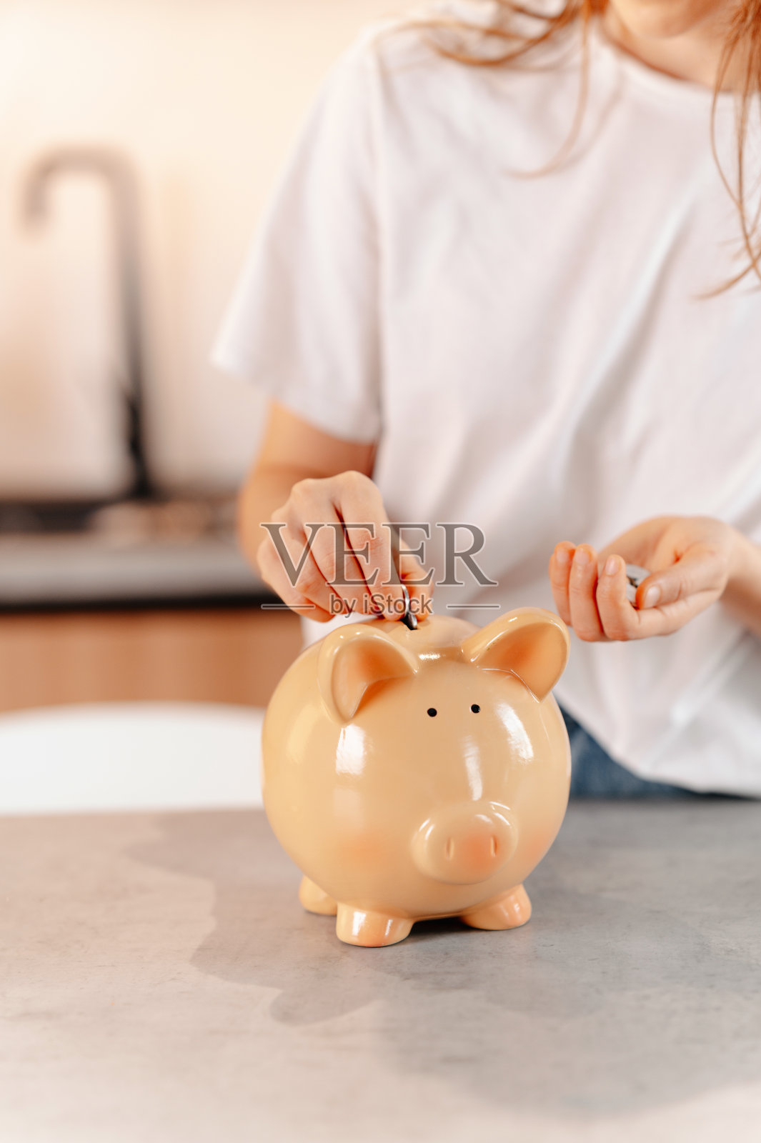 女性双手在存钱罐里存钱的垂直无脸镜头。照片摄影图片