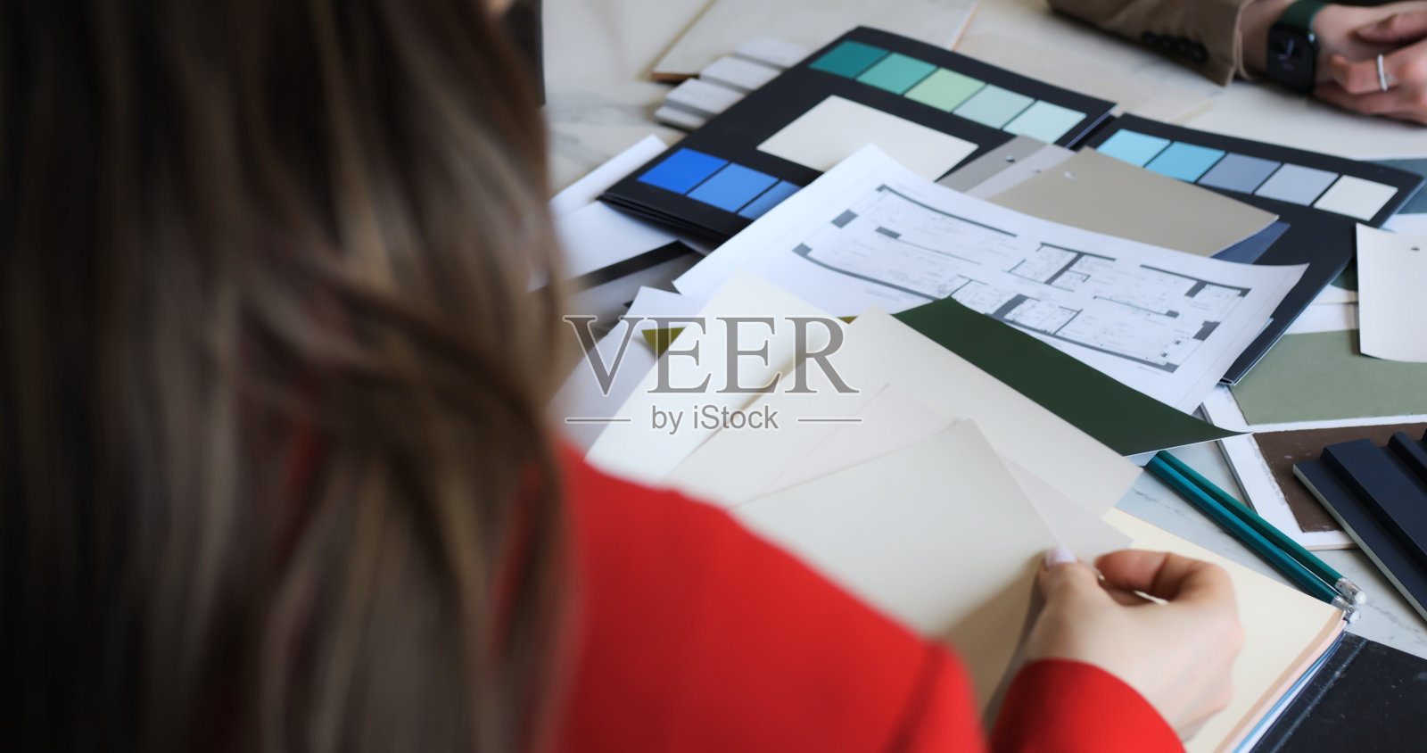 房地产经纪人在战略会议期间评估物业蓝图。专业人士分析，讨论发展计划，市场策略。详细的会话可以提高对蓝图的理解。照片摄影图片