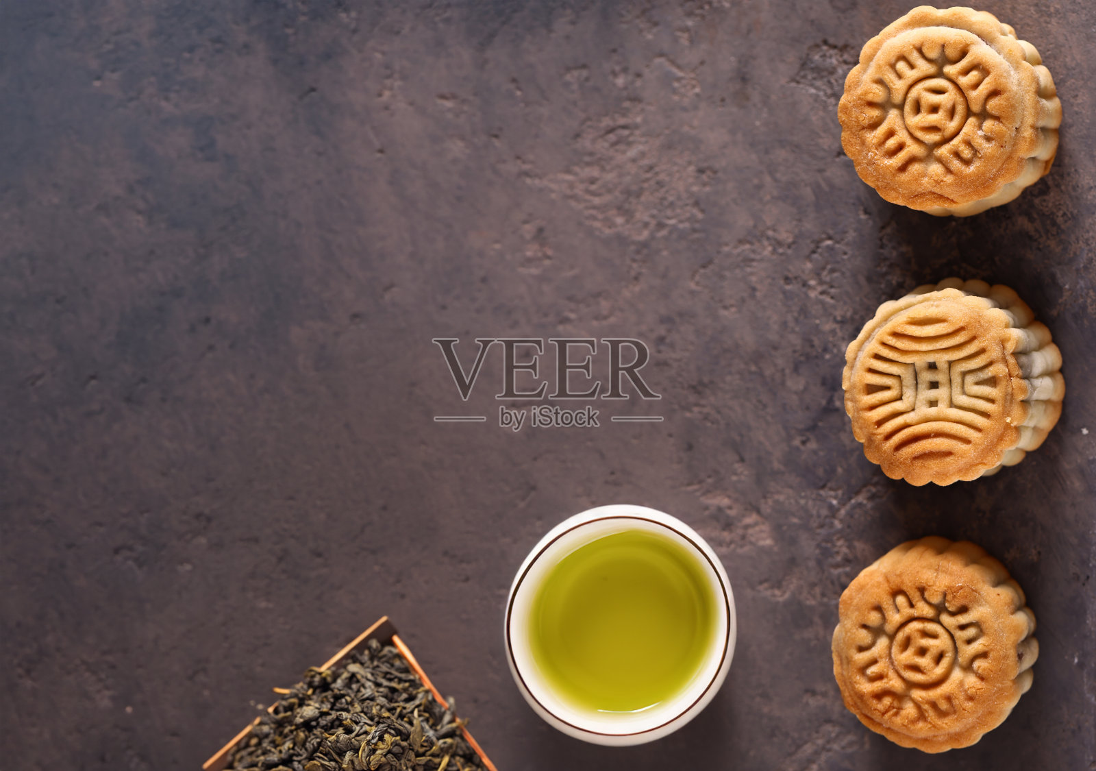 桌上摆着传统的月饼和绿茶照片摄影图片