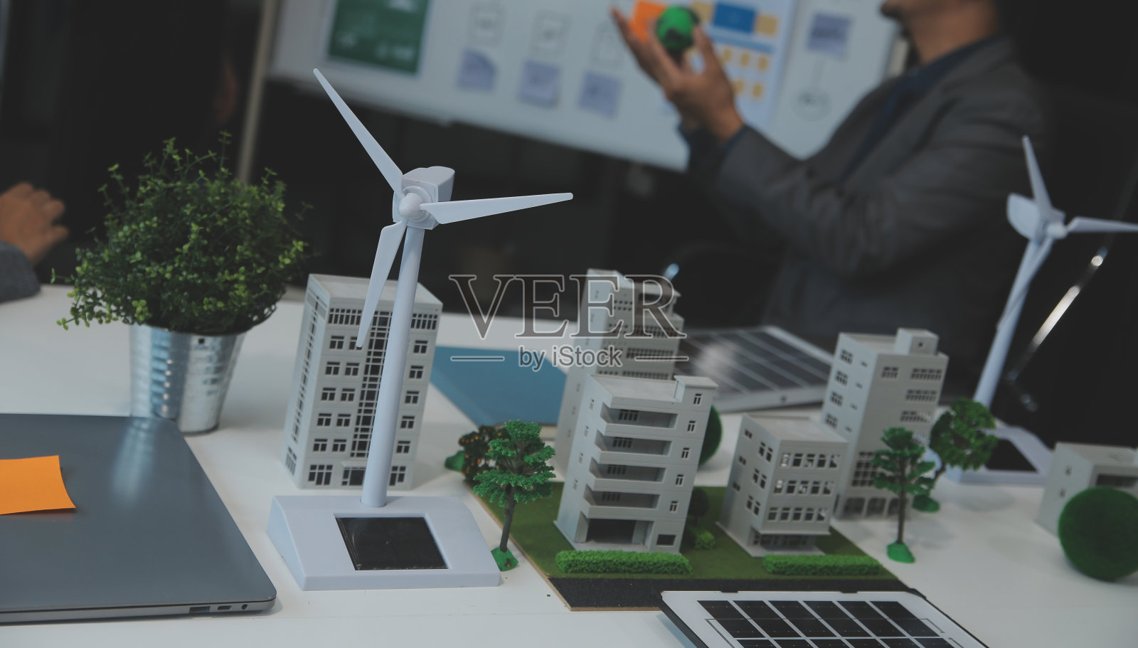 商务人士在公司办公室就风能问题进行咨询。商业团队讨论风车和替代绿色能源。在现代化的办公室开行政会议照片摄影图片