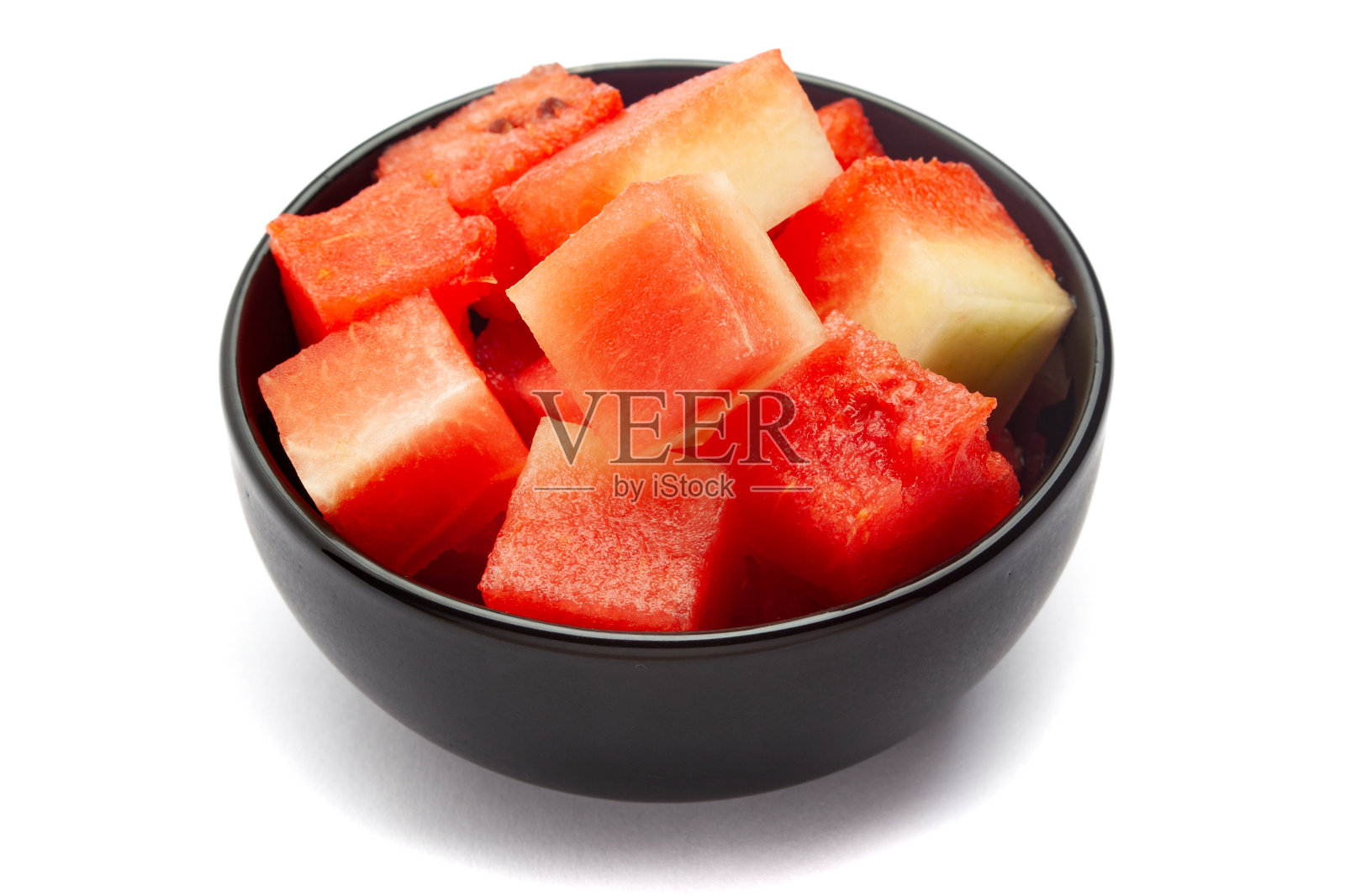 一个黑色的陶瓷碗，里面装满了有机西瓜片。照片摄影图片