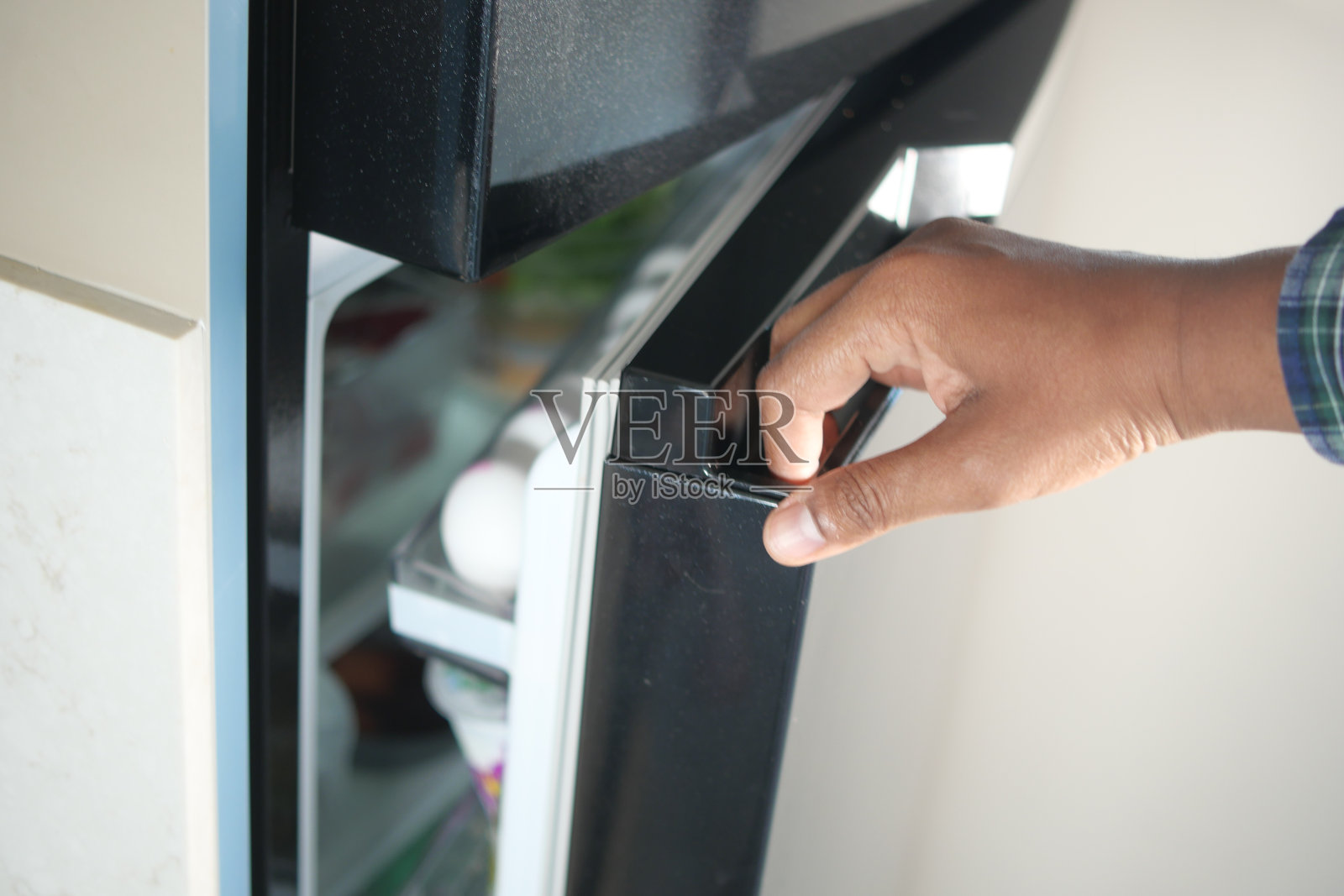 半打开的冰箱里放着食物和蔬菜，照片摄影图片