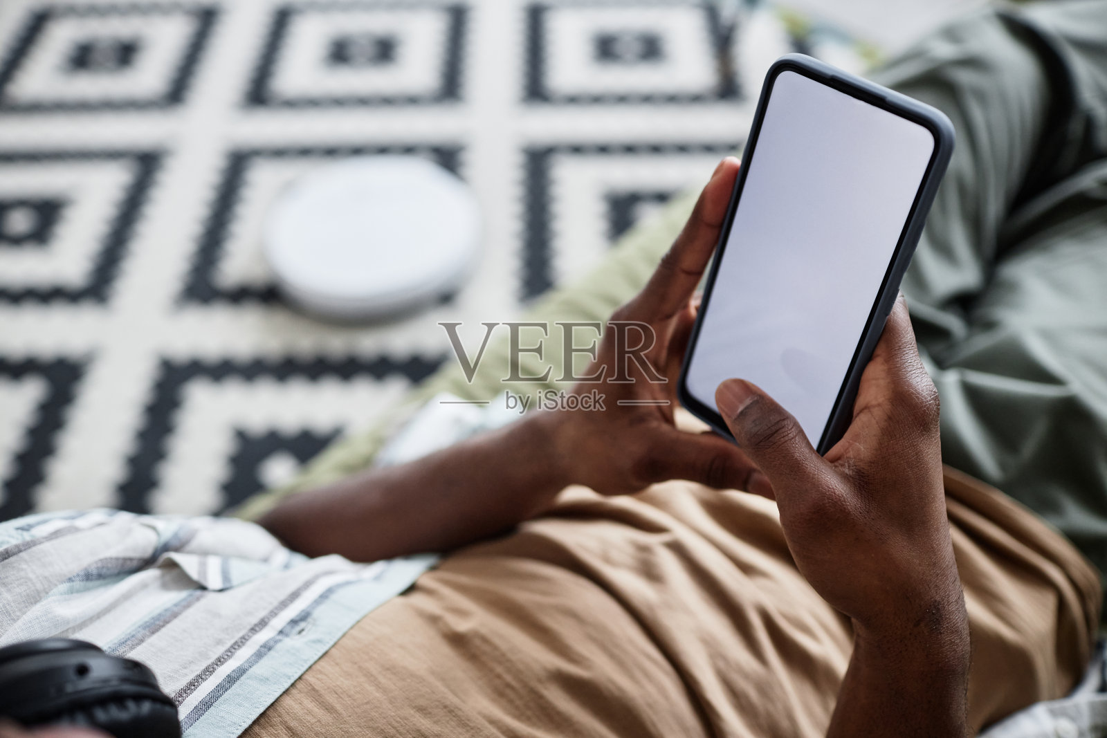 不可识别的男子在智能手机上使用吸尘器应用程序照片摄影图片