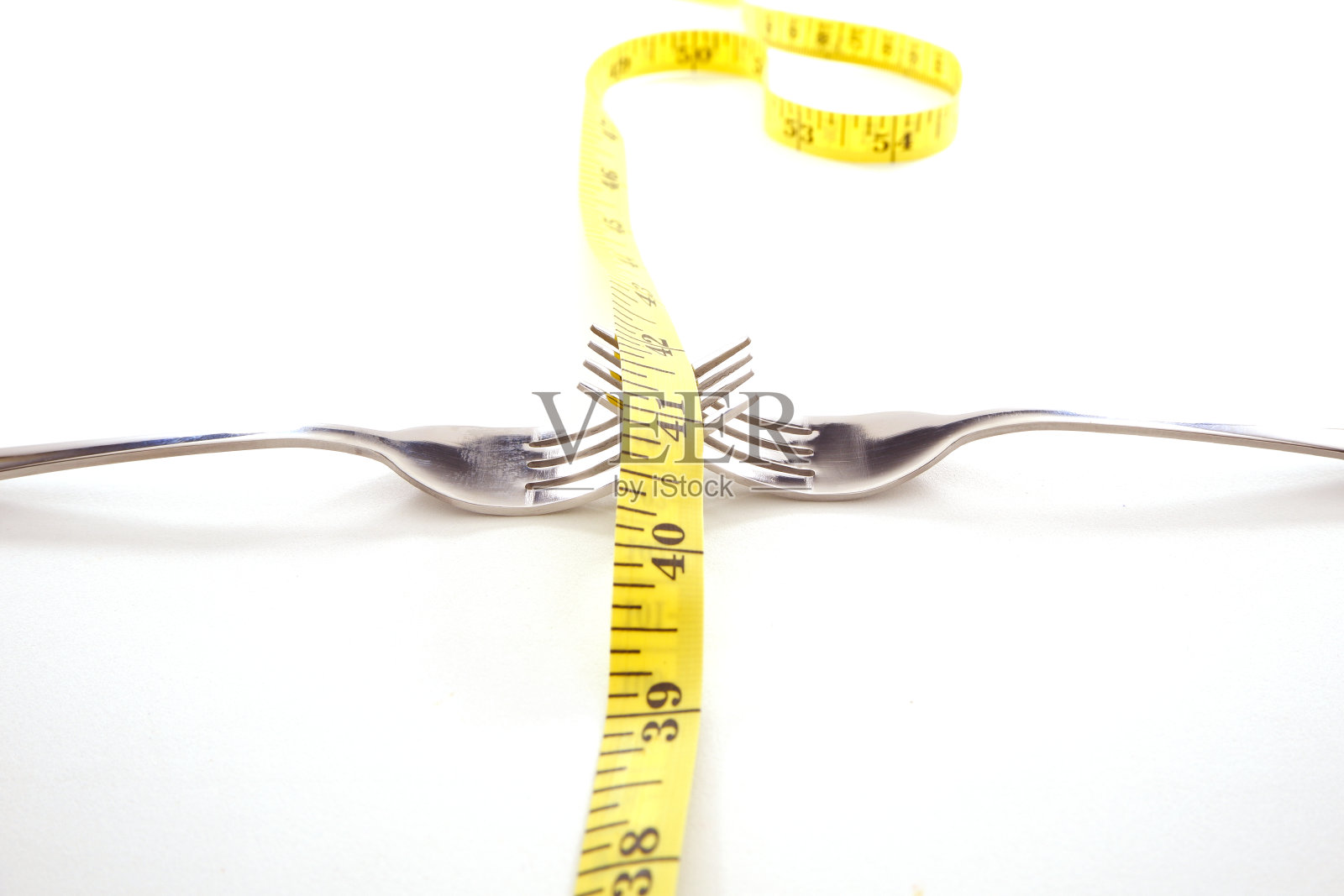 白色背景上的银色餐叉和卷尺特写照片摄影图片