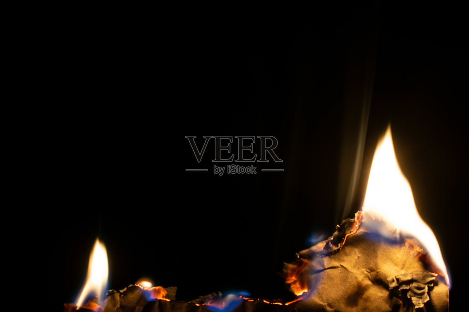 燃烧的纸，在黑色背景上发光的纸边照片摄影图片