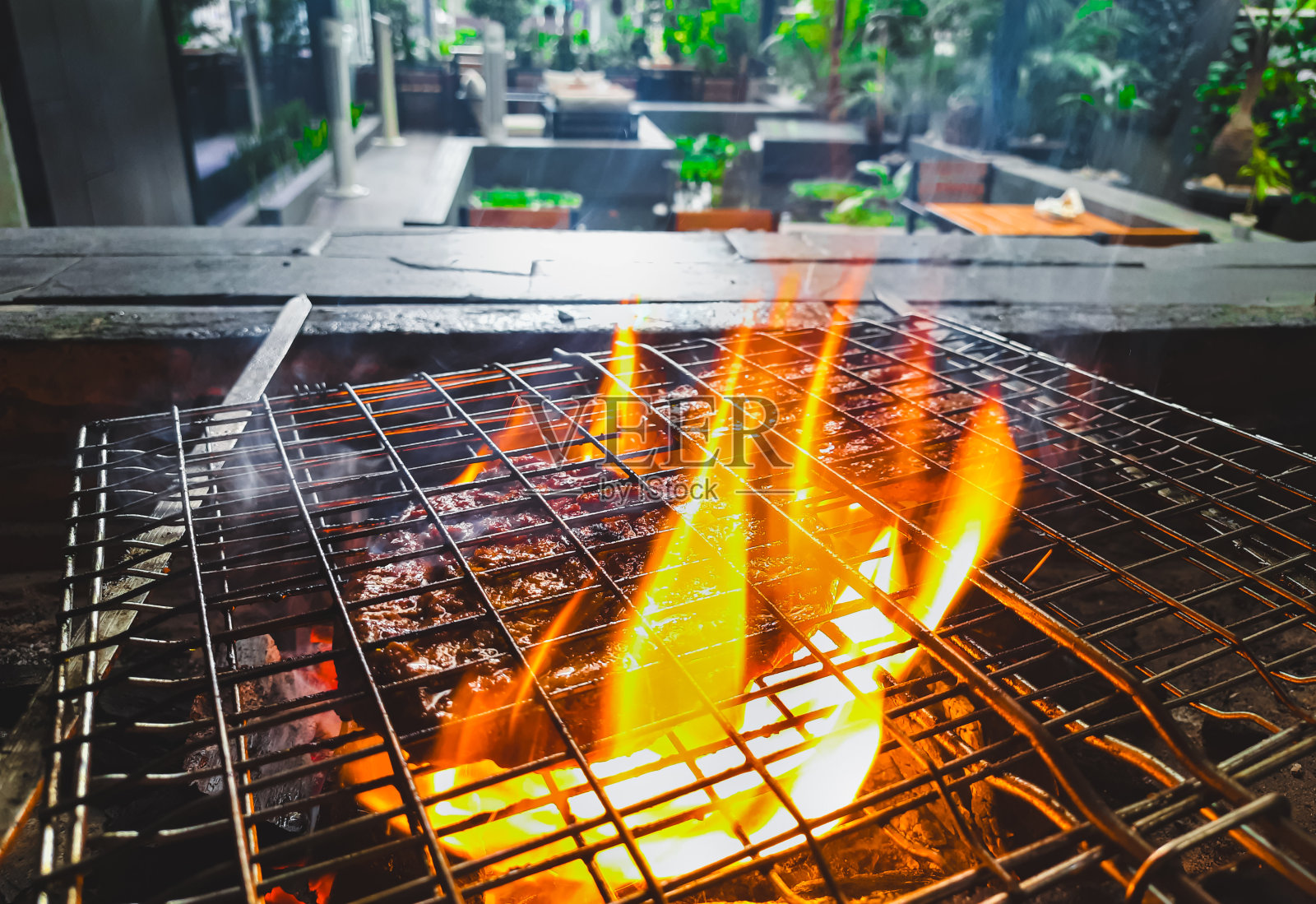 什锦美味的烤肉架上的烟雾和火焰。烤肉串在燃烧的烤架上把肉串和蔬菜串在一起。照片摄影图片