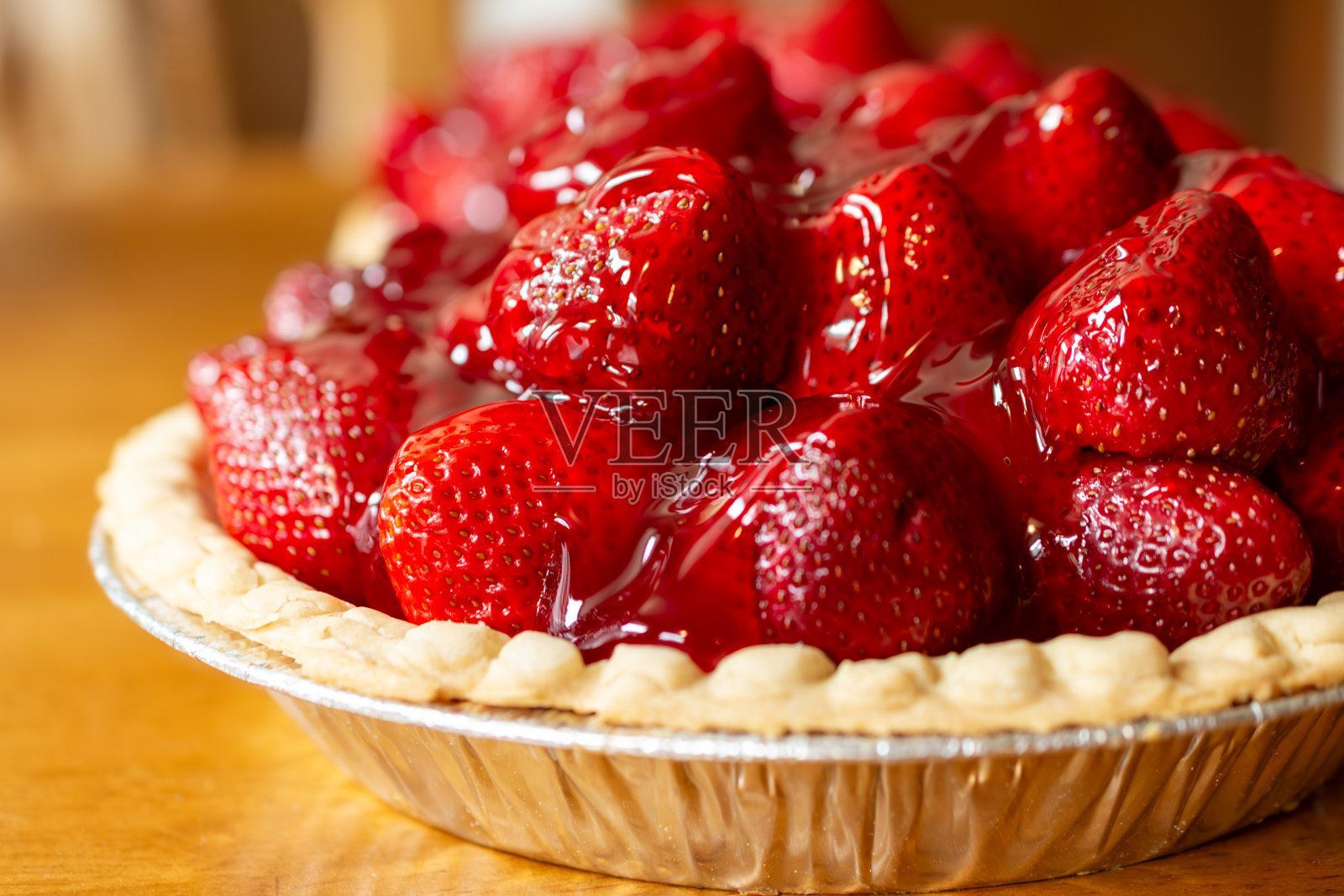 制作冰镇草莓糖霜派:让草莓糖霜滴在浆果上。上桌前先放凉。照片摄影图片