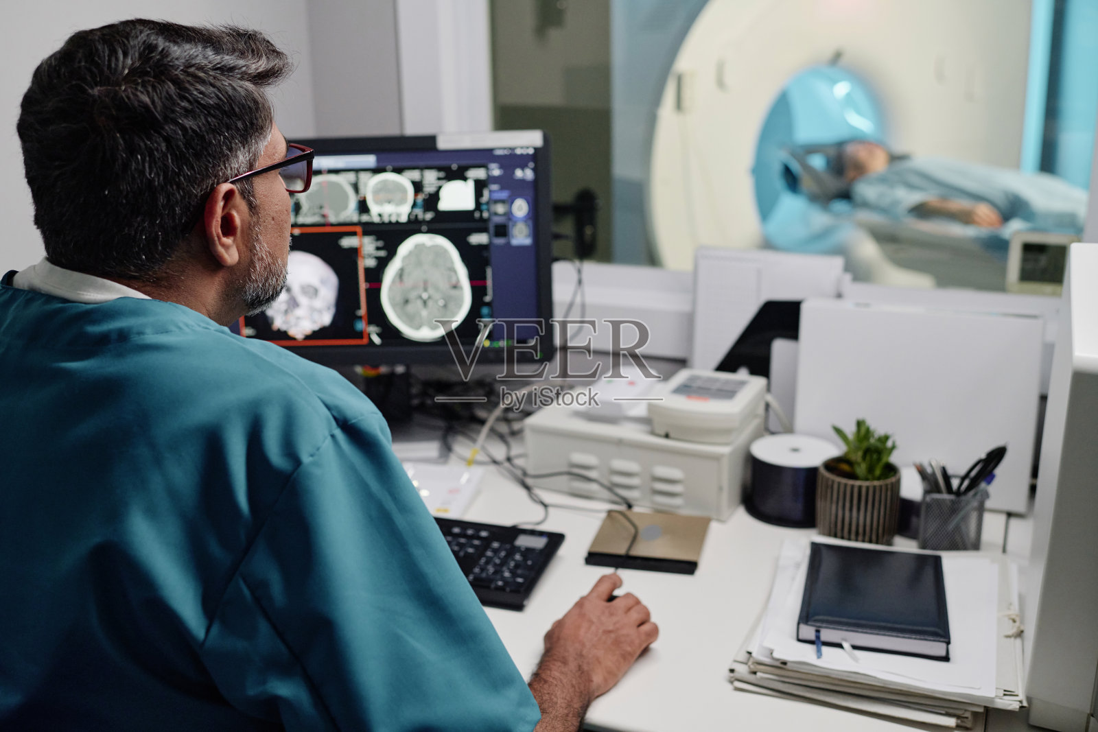 医院放射技师对CT扫描仪的控制照片摄影图片