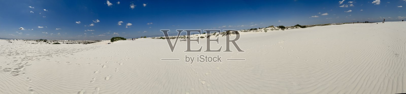 白色沙丘的全景与植物，蓝天，和脚印在白沙国家公园，新墨西哥州照片摄影图片