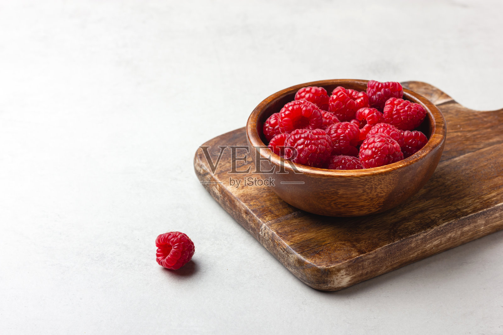 新鲜的树莓在浅灰色的背景木碗照片摄影图片