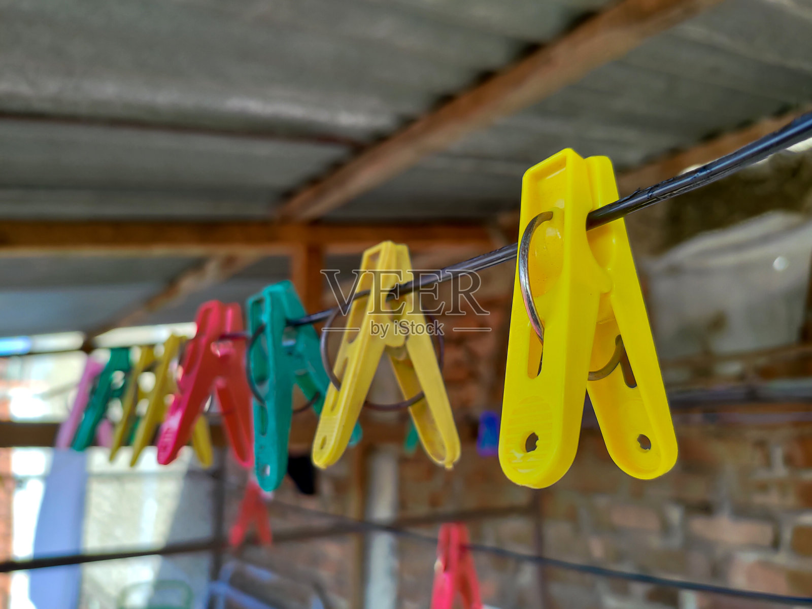 彩色的衣夹挂在绳子上。模糊的背景照片摄影图片