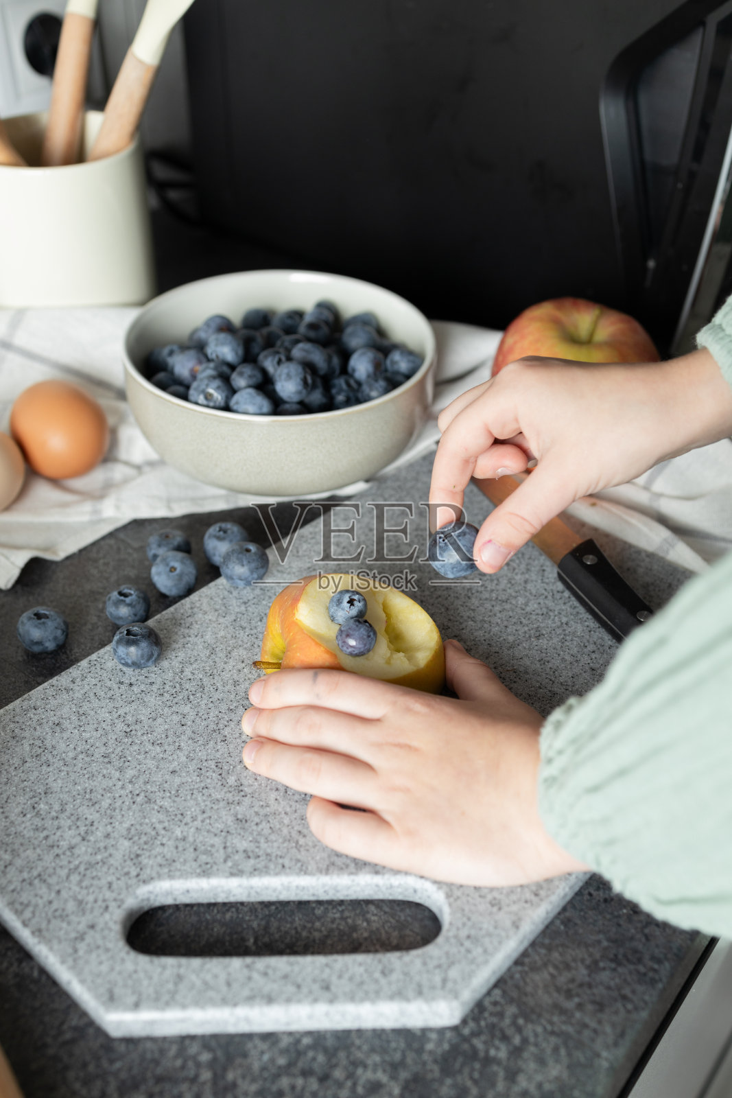 孩子的手在石头砧板上玩苹果和蓝莓照片摄影图片