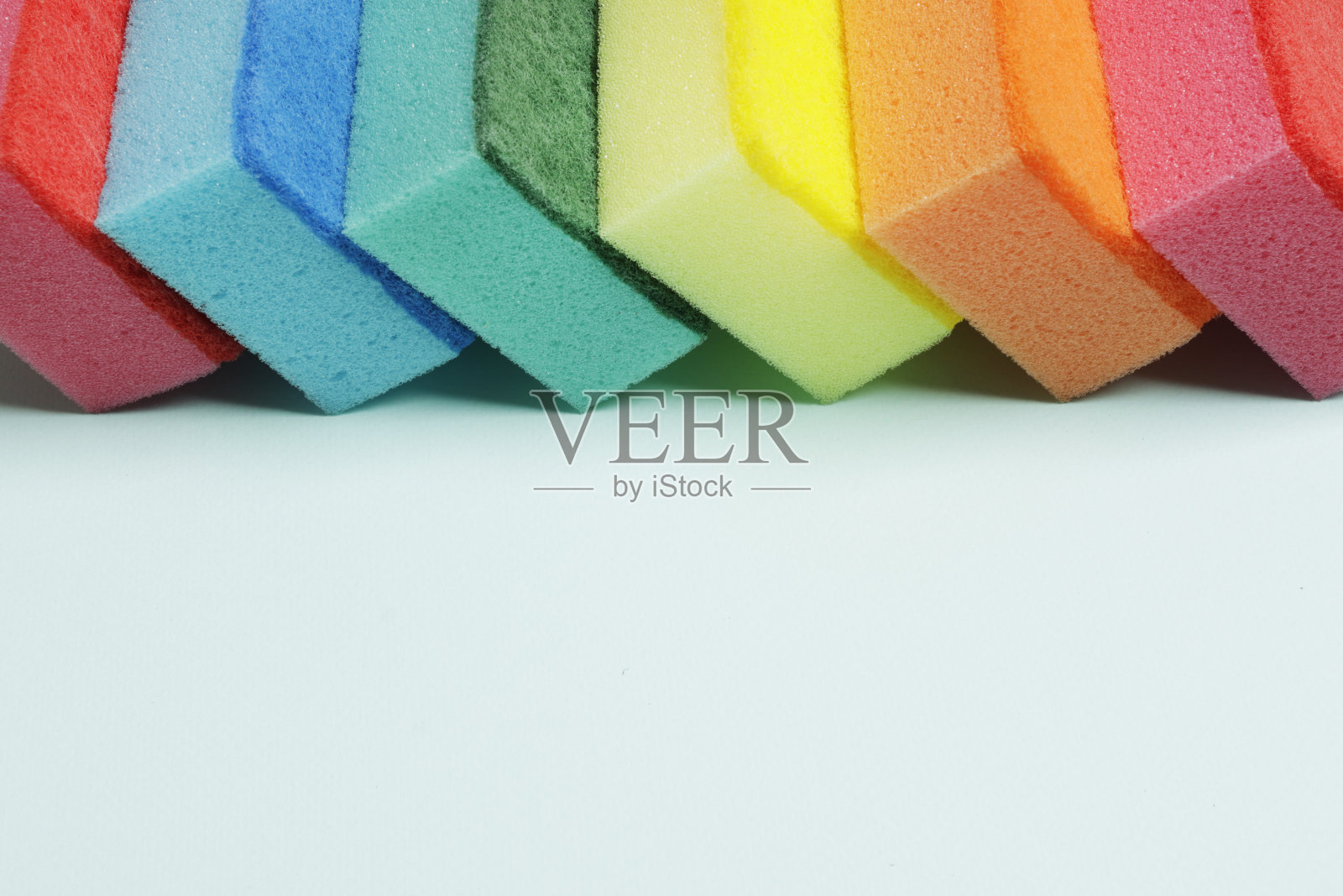 在蓝色的背景上用了很多不同颜色的海绵。放文字的地方。前视图。照片摄影图片