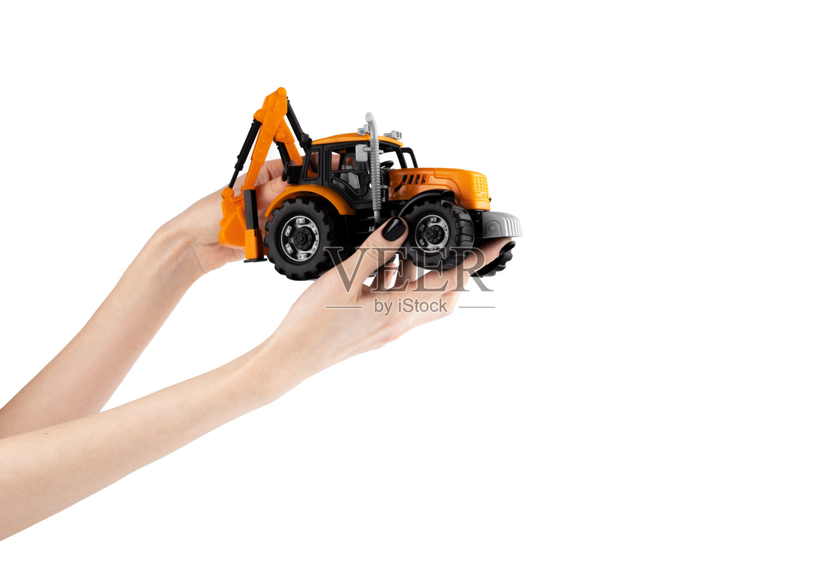 拖拉机在女性手中。挖掘机。年级的学生。孩子们的玩具。拖拉机孤立在白色背景上照片摄影图片
