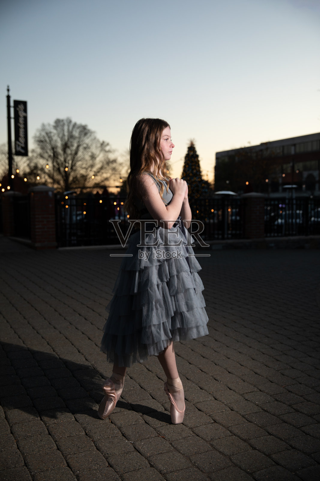 少年芭蕾舞演员在黑暗中撑着带光的伞照片摄影图片