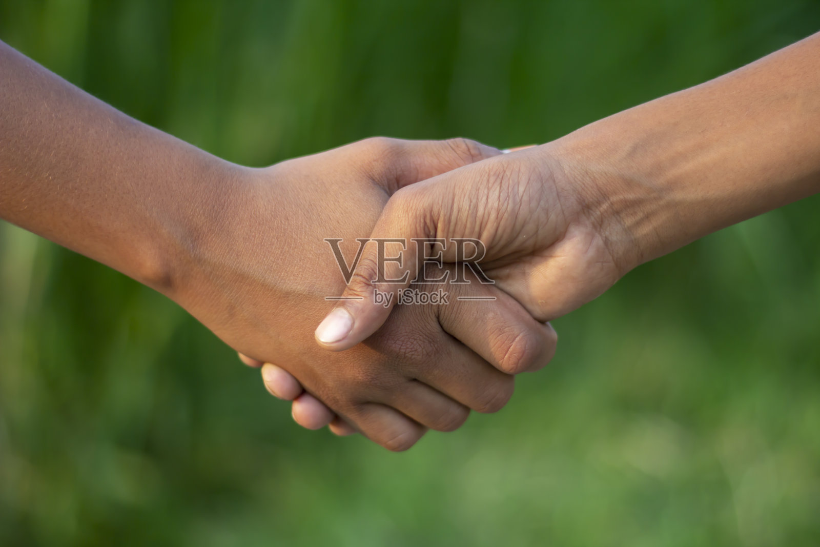 一个男人和另一个男人握手，模糊的背景照片摄影图片