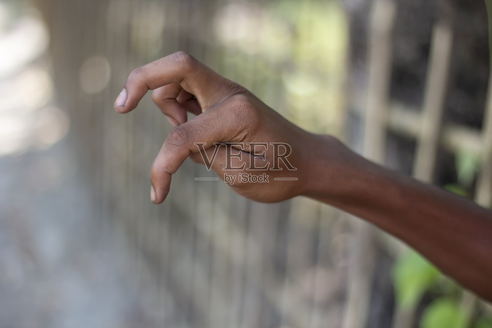 一个男人的两只手指向下指着，背景模糊照片摄影图片