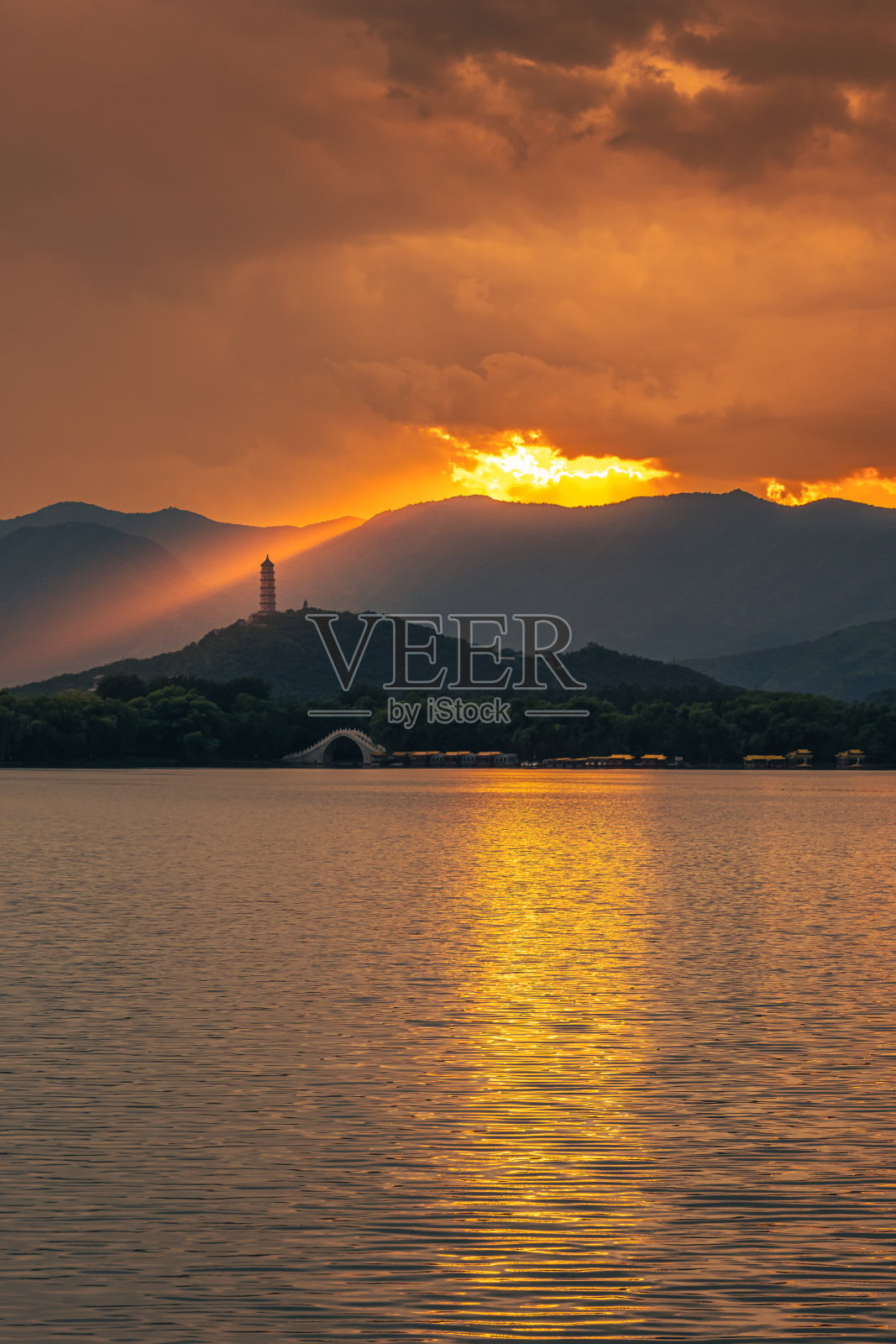 日落时分，佛祖的光芒照耀在北京颐和园的塔上照片摄影图片