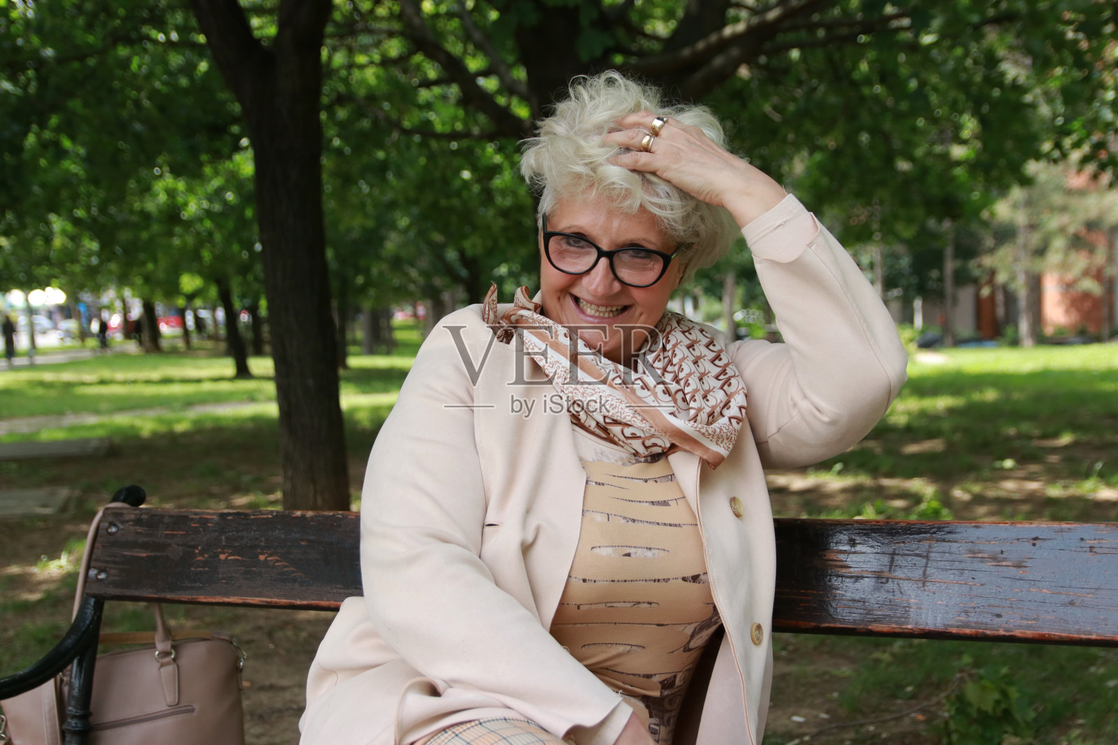 快乐的大四女生坐在公园的长椅上照片摄影图片