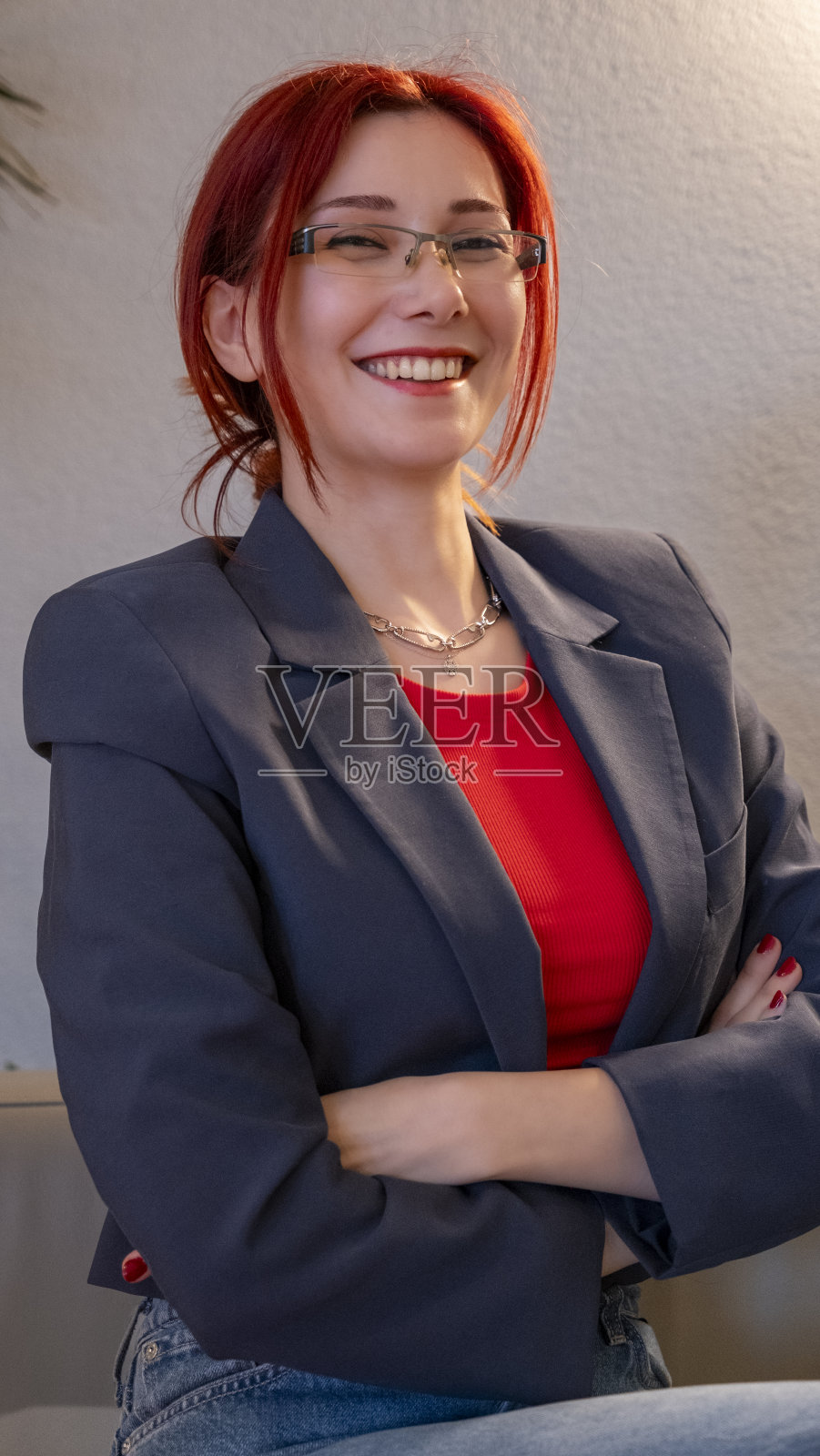 一位美丽迷人的红发女商人在办公室外工作。照片摄影图片