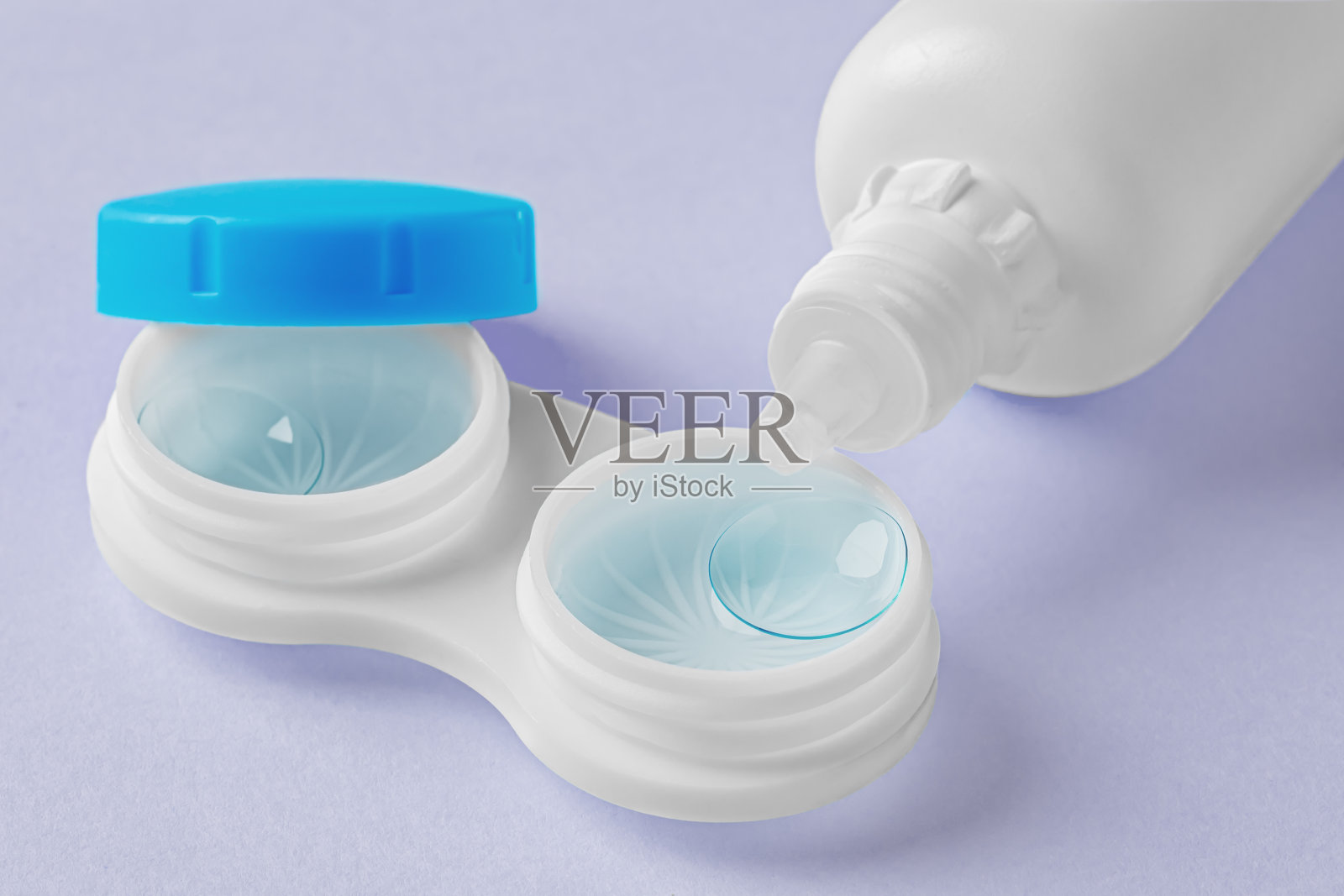 隐形眼镜在容器与溶液瓶0在柔和的紫色背景照片摄影图片