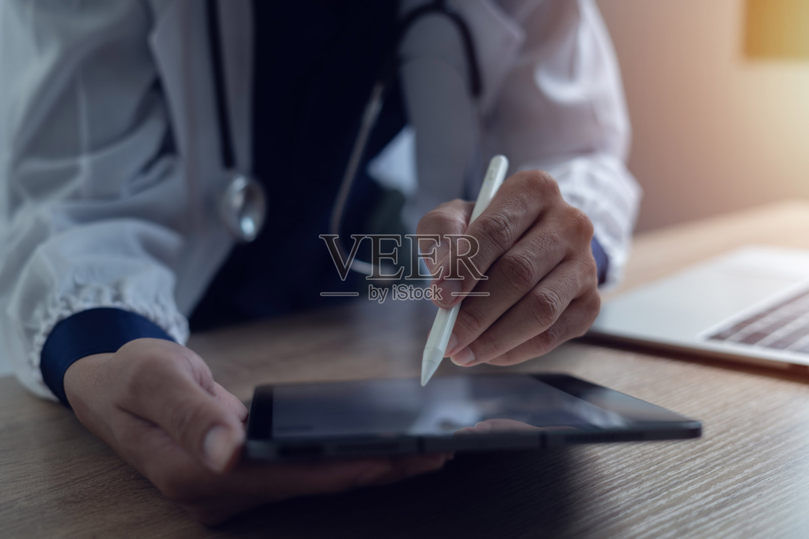 医生在笔记本电脑上工作的特写，医生办公室桌子上的数码平板电脑医疗保健概念照片摄影图片