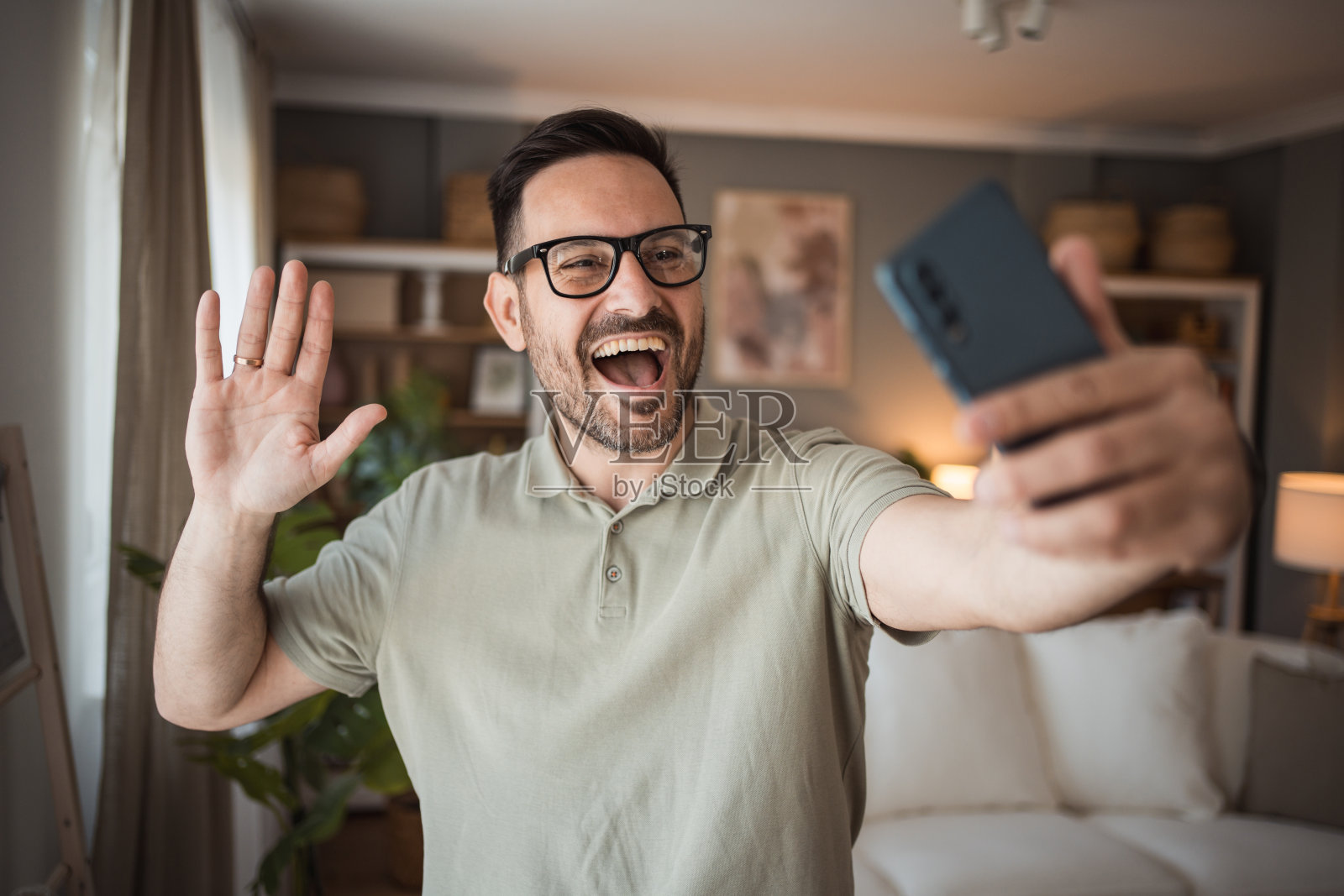 自拍时刻——一个年轻人在他公寓的客厅里拍了一张照片照片摄影图片