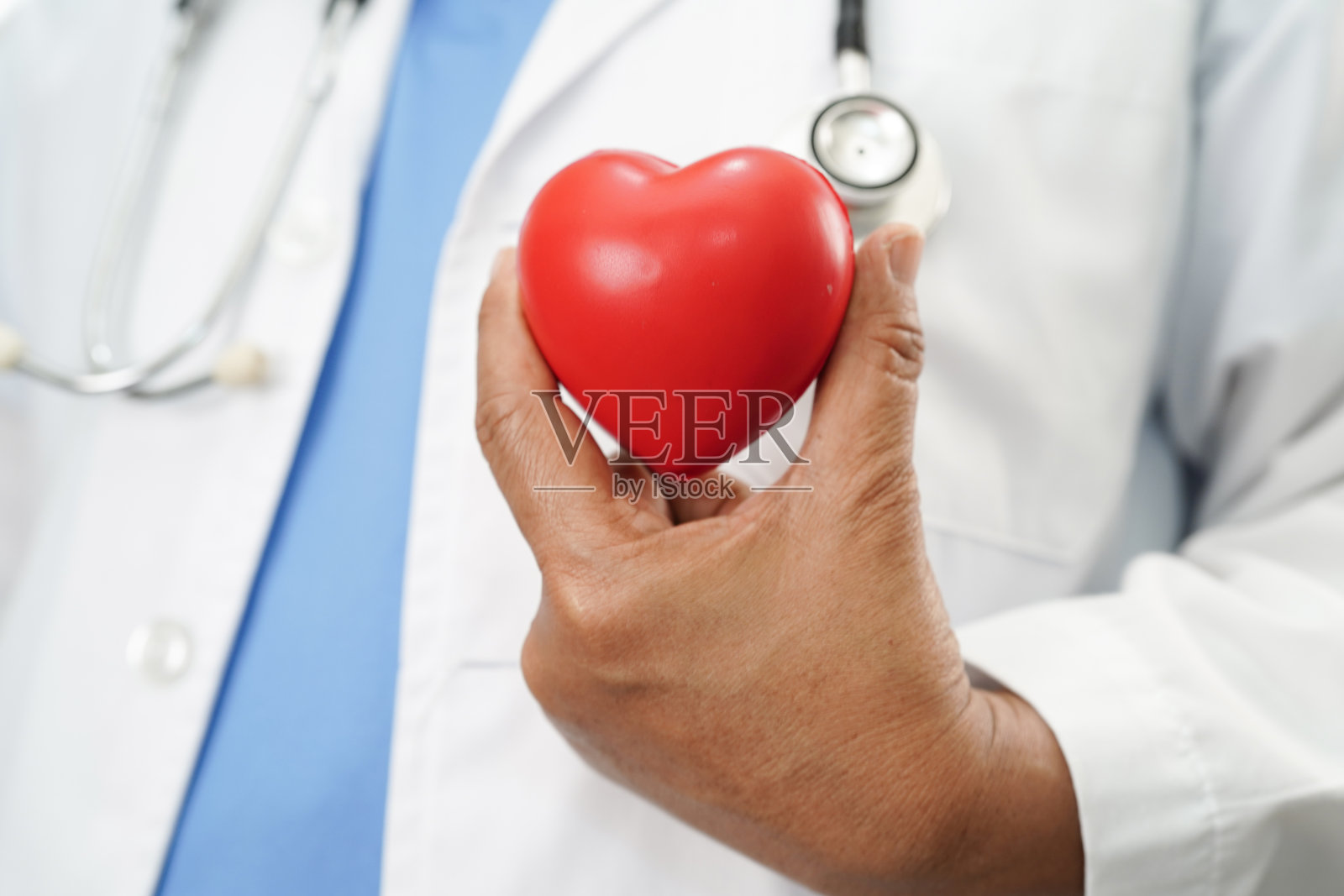医生在医院里抱着一颗红心，心脏病发作。照片摄影图片