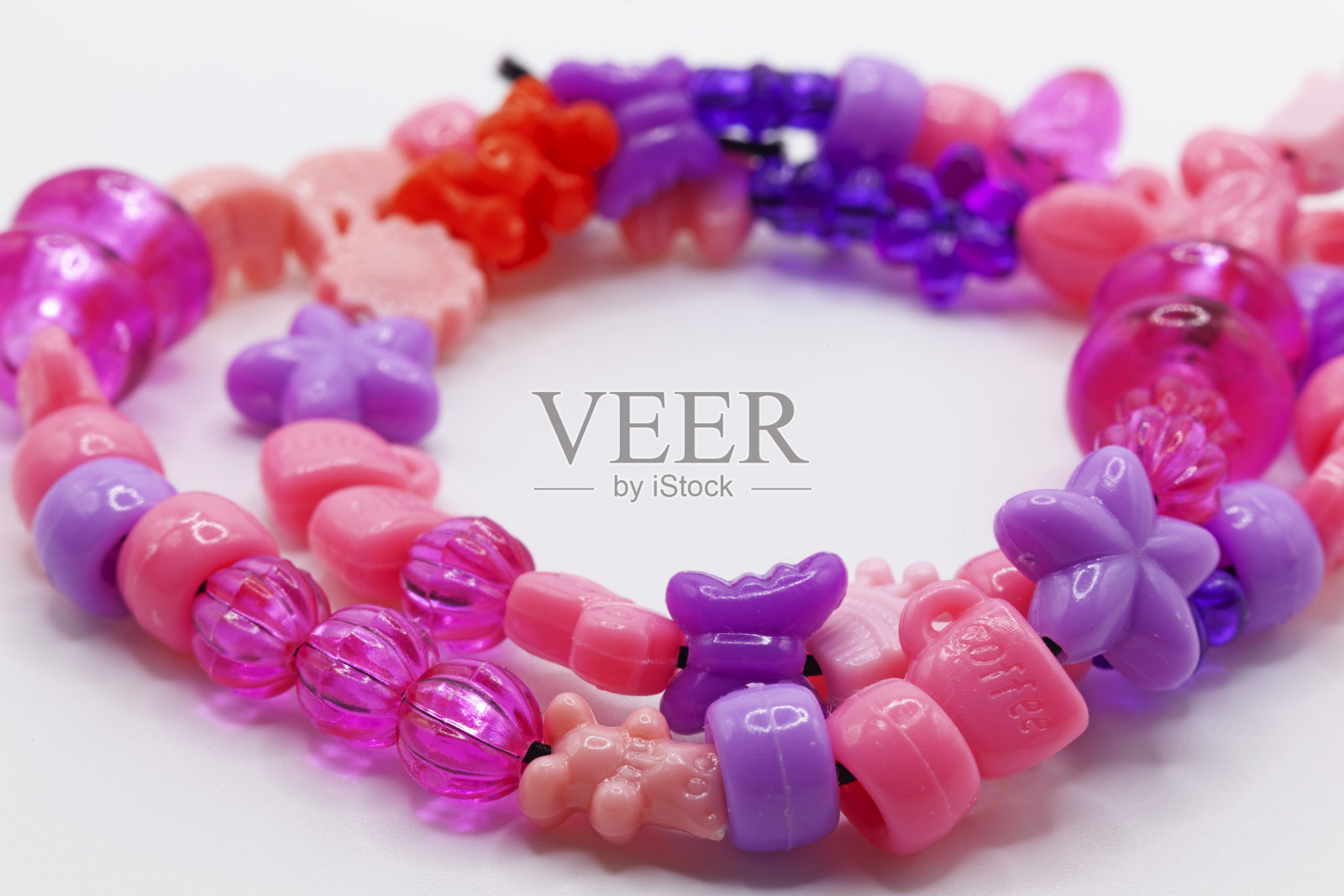 一个小女孩做的项链躺在白色的背景上照片摄影图片