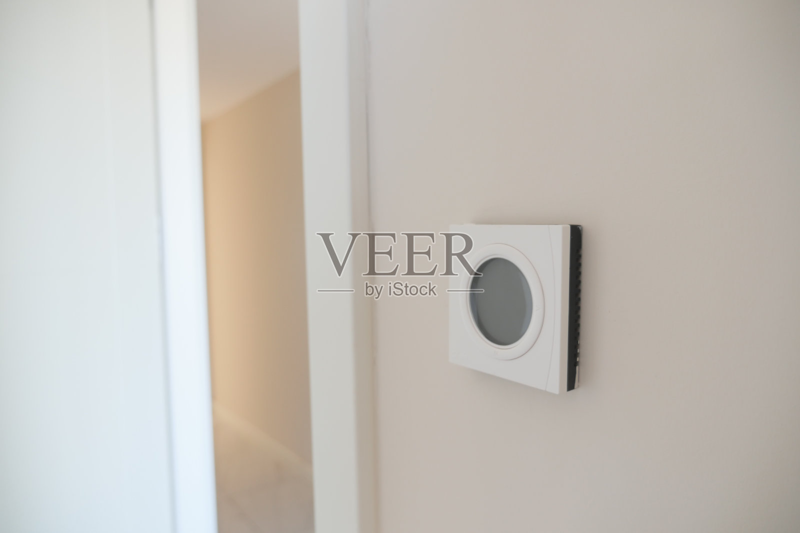 白墙上的智能恒温器，可实现最佳的家庭温度控制照片摄影图片