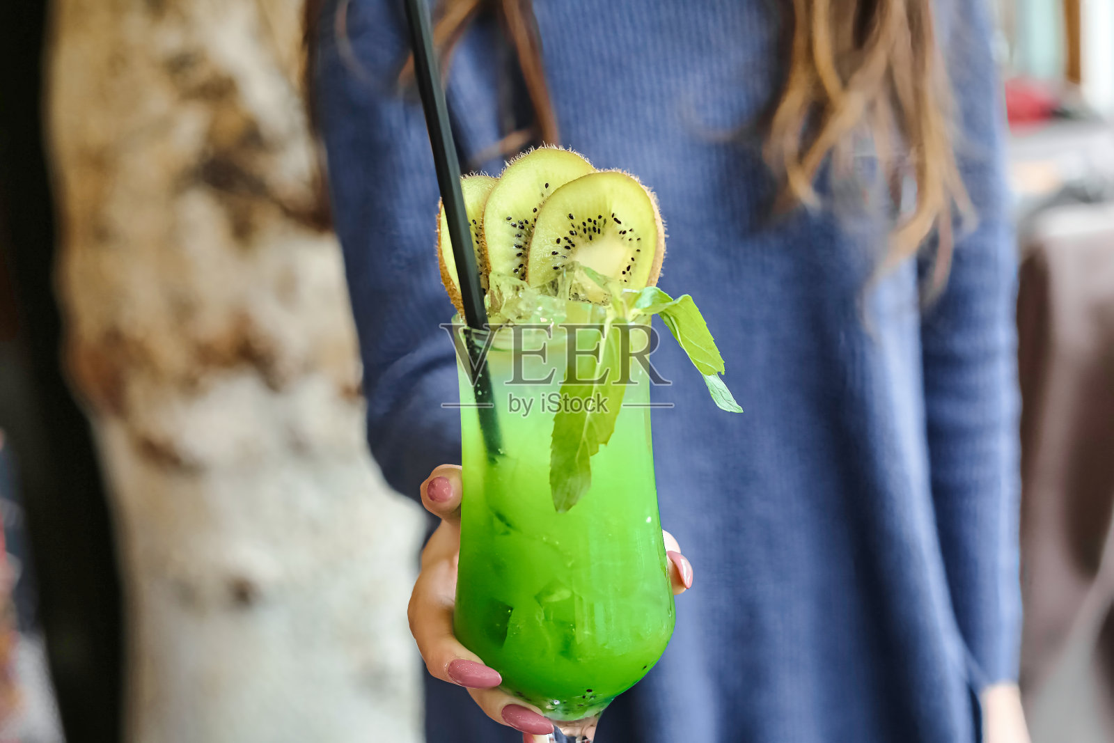 拿着绿色猕猴桃饮料的女人照片摄影图片