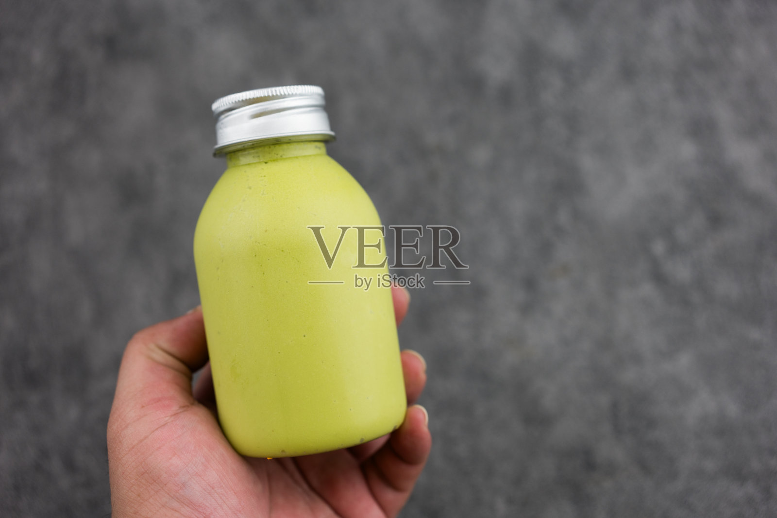 牛油果冰沙果汁在玻璃瓶在手照片摄影图片