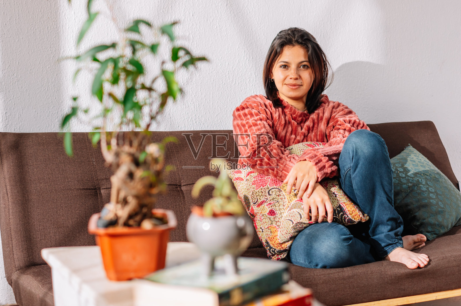 坐在沙发上看镜头的拉丁女人照片摄影图片