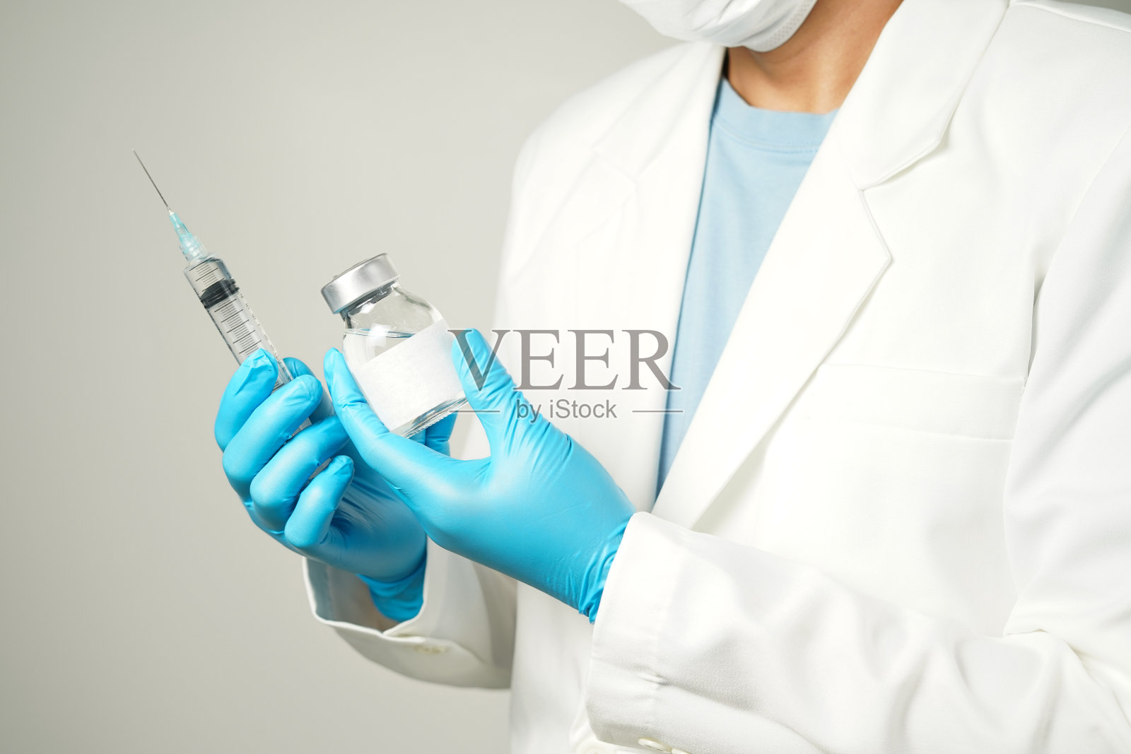 医生或科学家手持装有安瓿疫苗的注射器，用于注射的瓶子照片摄影图片