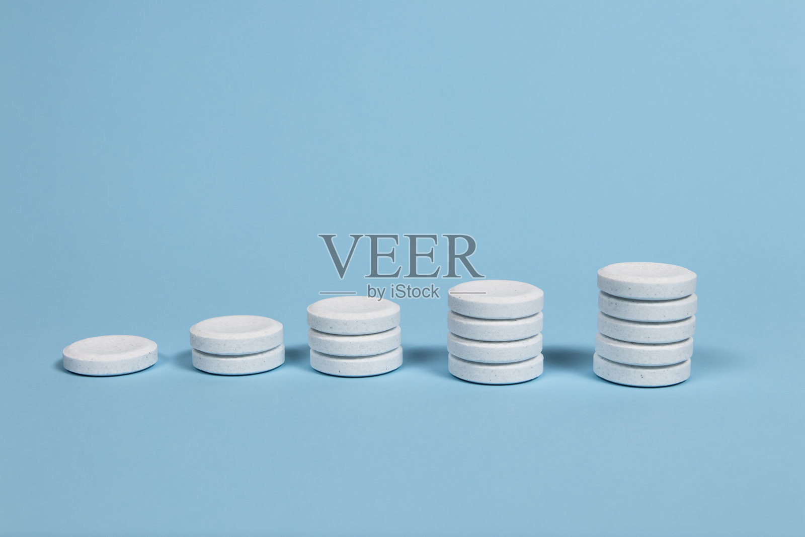 泡腾片堆在淡蓝色的背景上照片摄影图片