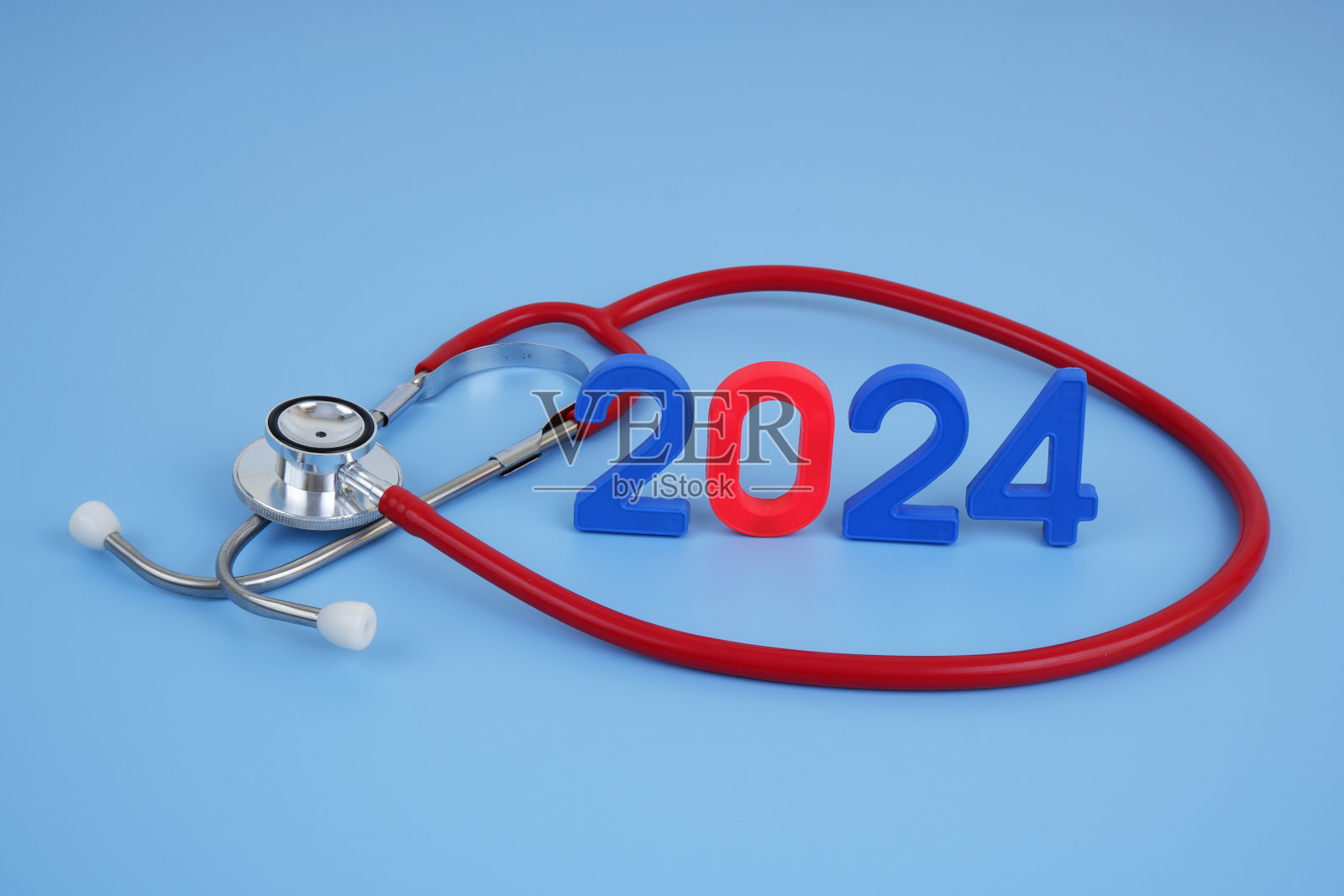 听诊器和蓝色背景上的数字2024。照片摄影图片