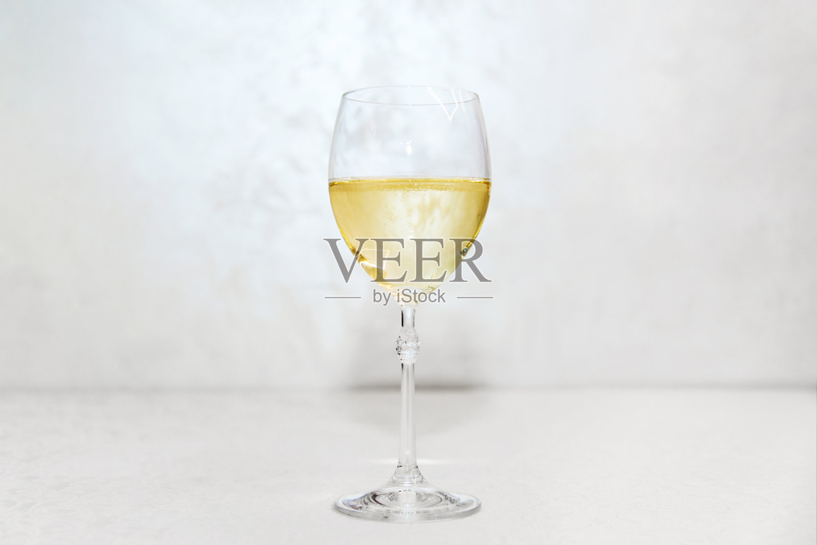 在室内的桌子上有一个满的酒杯。节日背景的婚礼，生日或圣诞节照片摄影图片