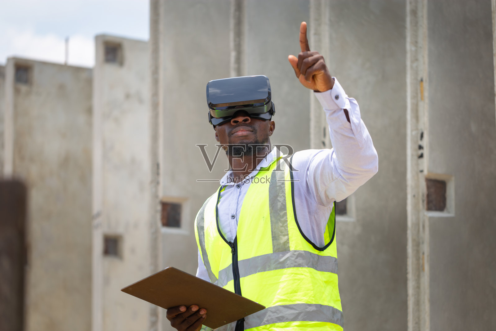 在建筑工地戴着虚拟现实眼镜的工程师，在工作的建筑工人照片摄影图片