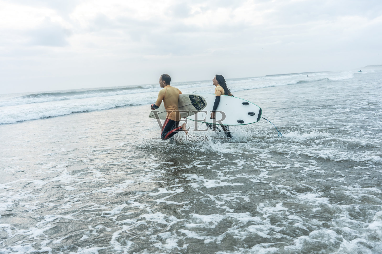 两个朋友冲向水，冲浪。照片摄影图片