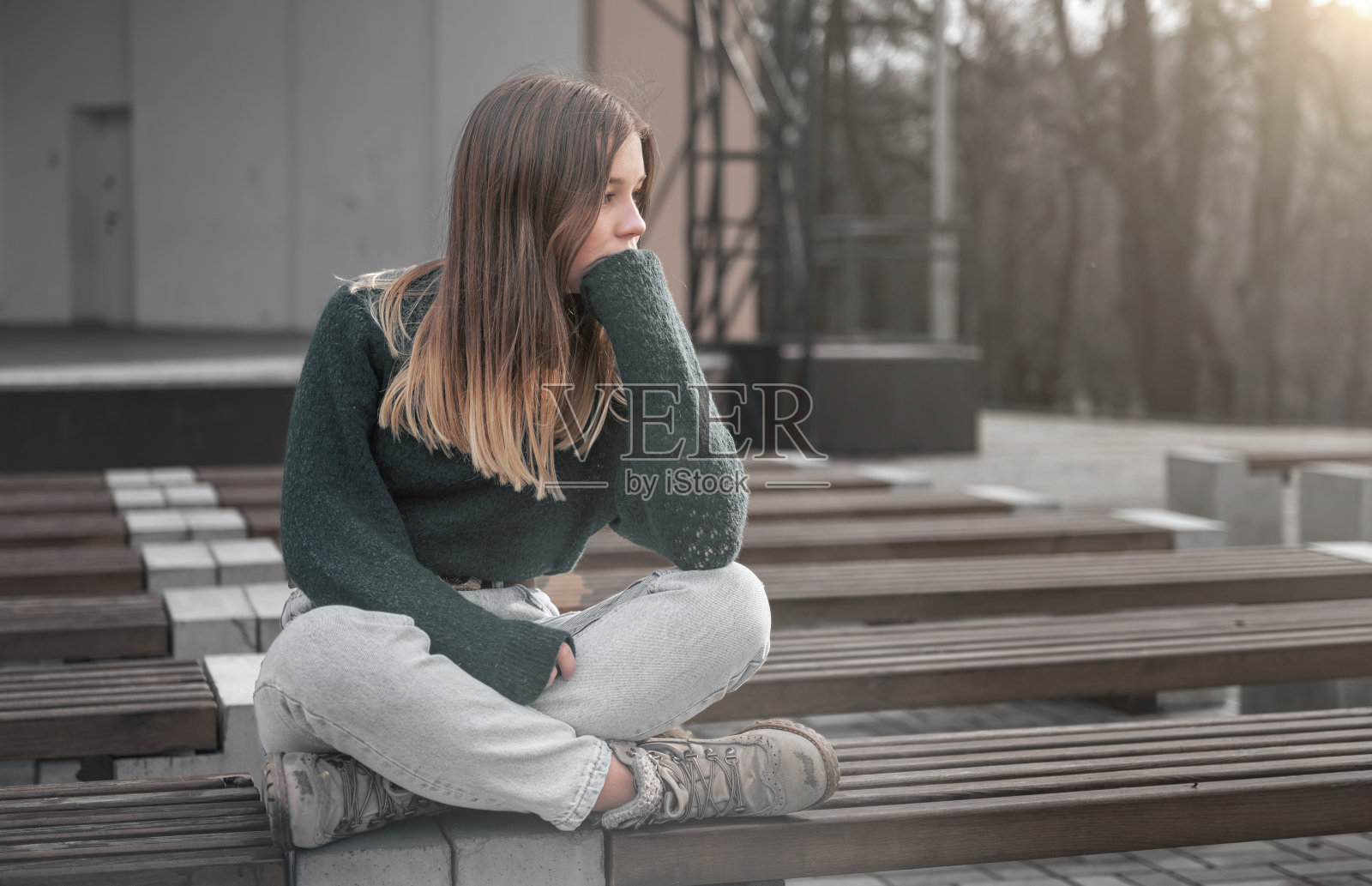 孤独的悲伤女孩。公园长椅上的悲伤少女。户外的单身女孩照片摄影图片