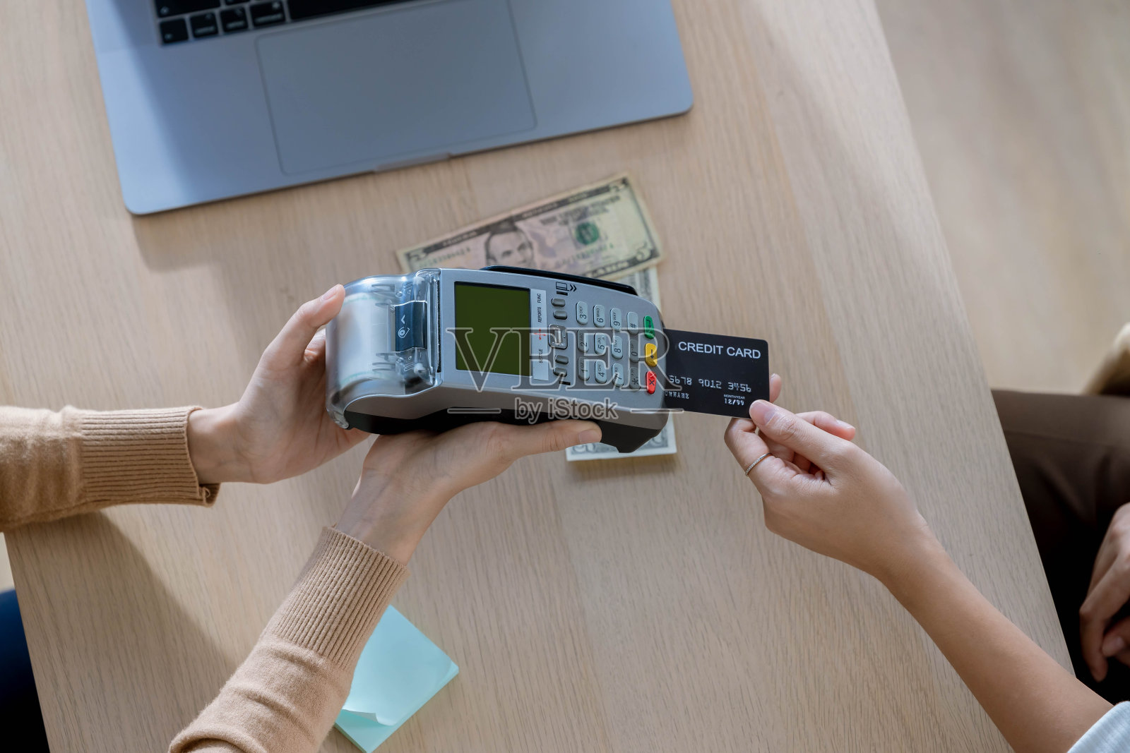 顾客用信用卡付款给接待员。无现金技术和信用卡支付概念。店主在零售商店，顾客用信用卡付款照片摄影图片