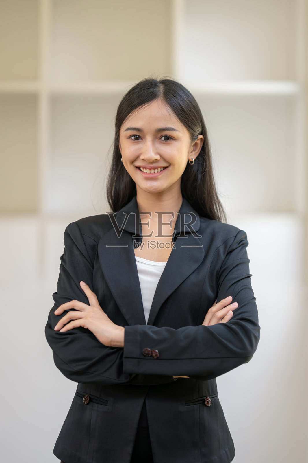 一个女商人双臂交叉站立的半身像。照片摄影图片