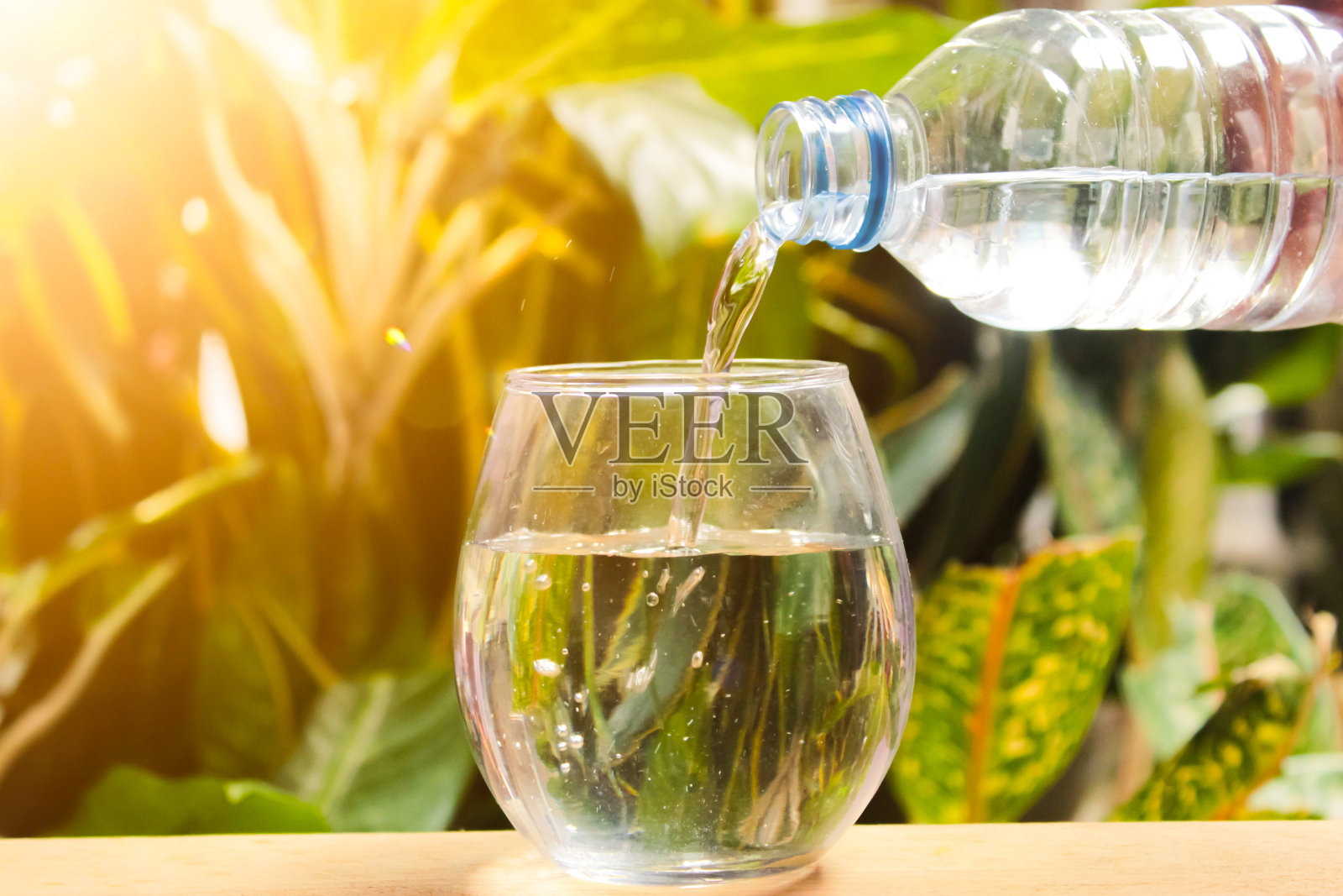 水从塑料瓶里倒进玻璃杯照片摄影图片